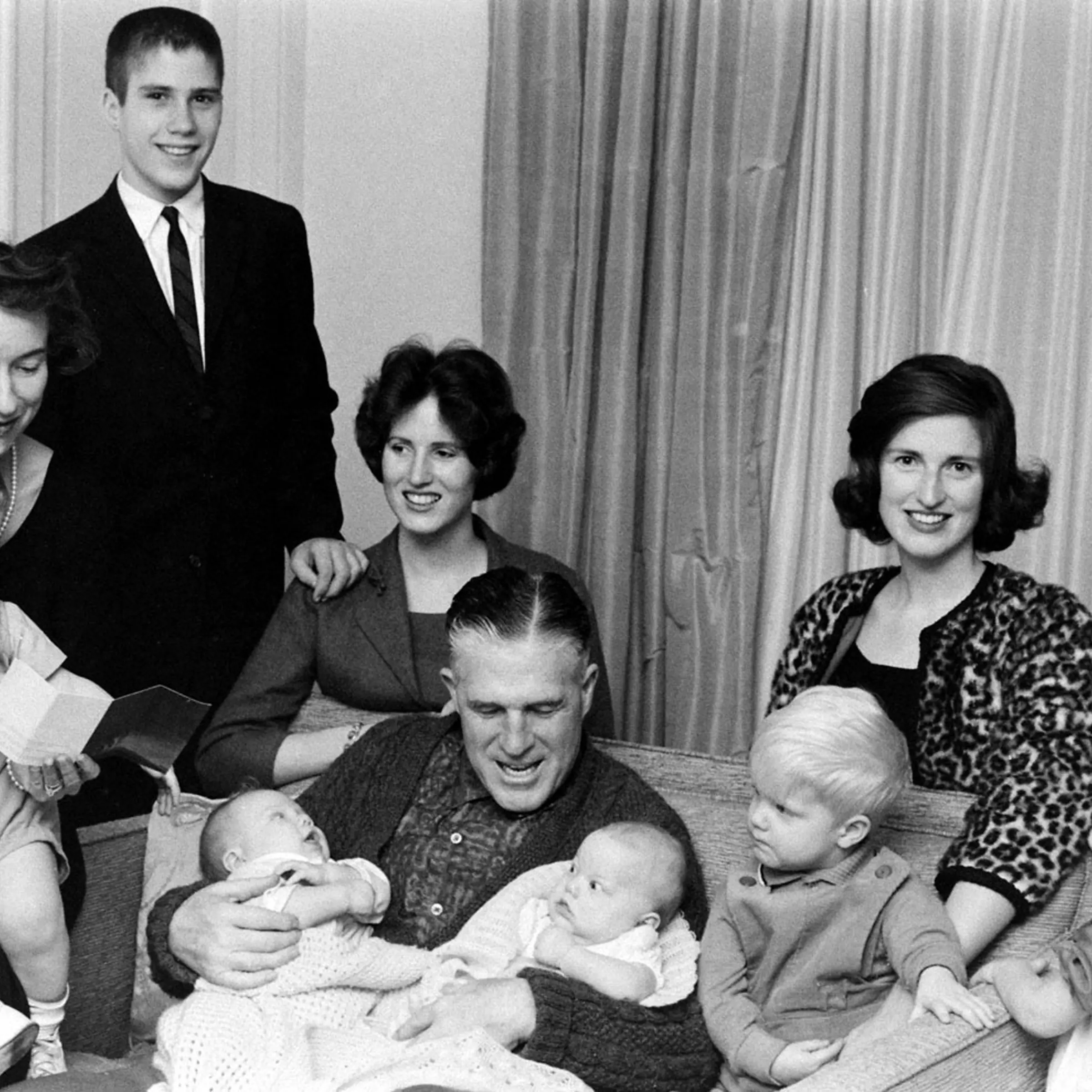 After Sunday services the Romneys crowd onto a sofa in living room. Son Mitt and married daughters Jane and Lynn are at the rear. From left, grandchildren are Gregory (held by Lenore), Douglas, Susan, Brett and Jody. Another son, Scott, is in England wit