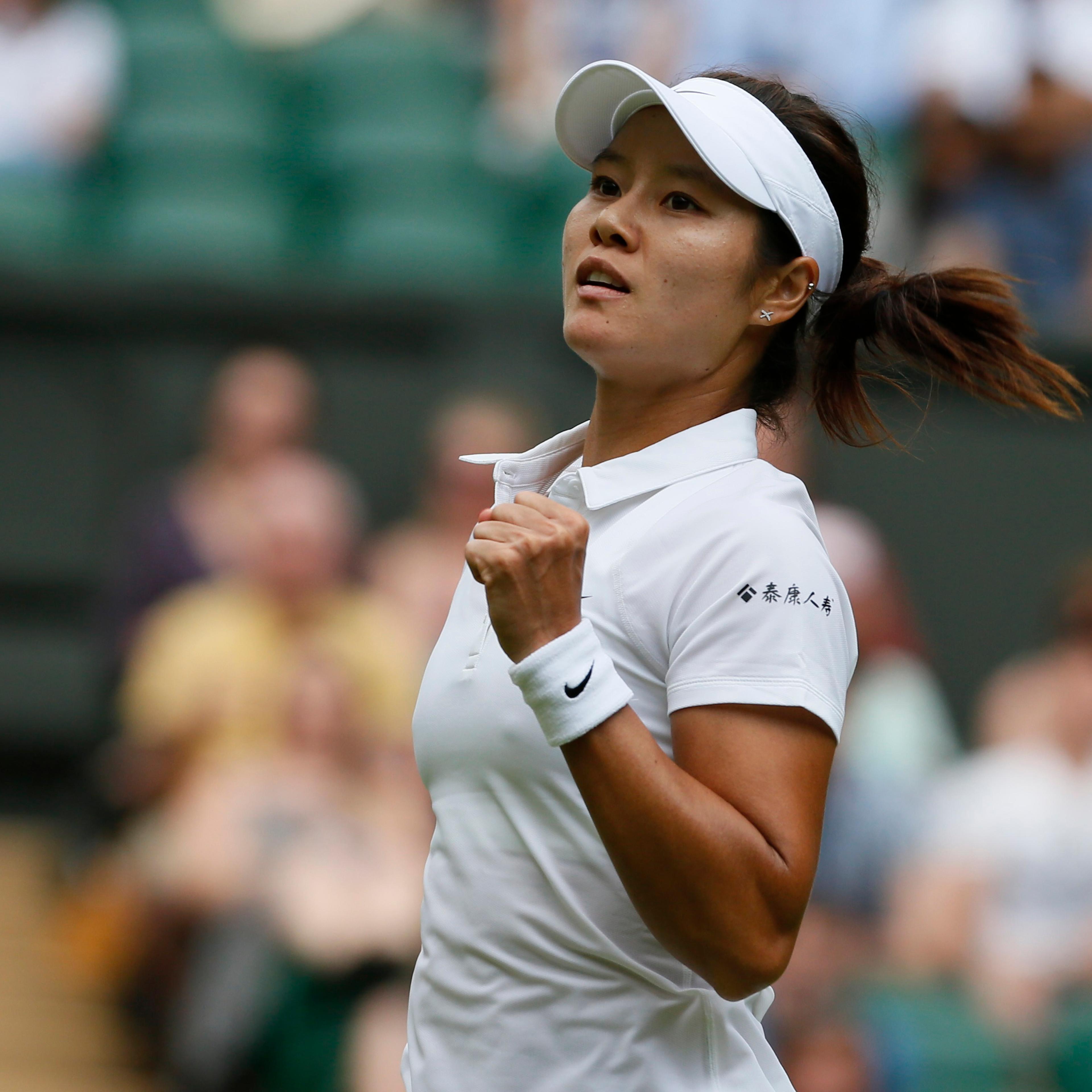 Li Na of China reacts after defeating Paula Kania of Poland in their women's singles tennis match at the Wimbledon Tennis Championships, in London
