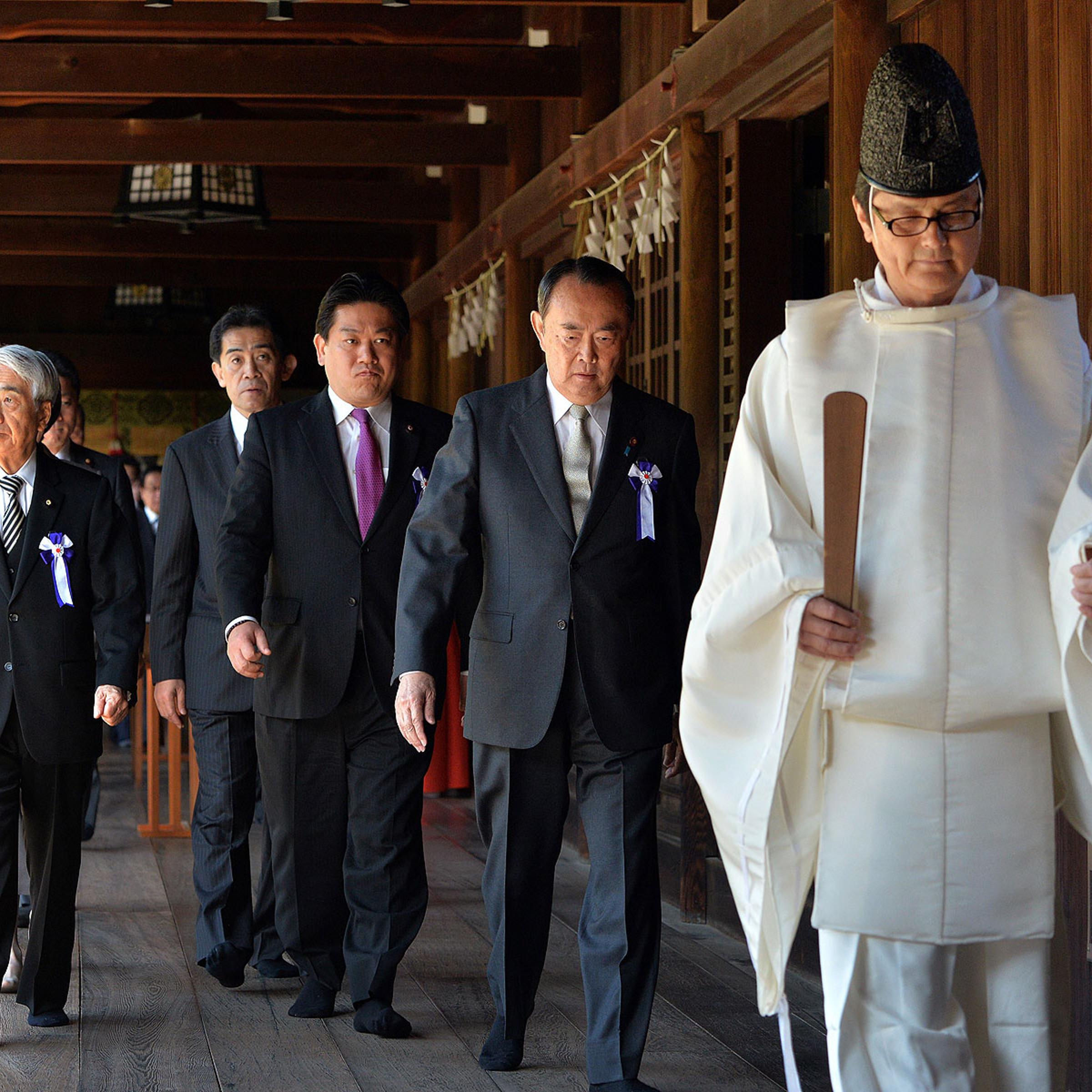 Japanese lawmakers follow a Shinto priest during a visit to the controversial Yasukuni Shrine to honor war dead during a spring festival in Tokyo on April 22, 2014