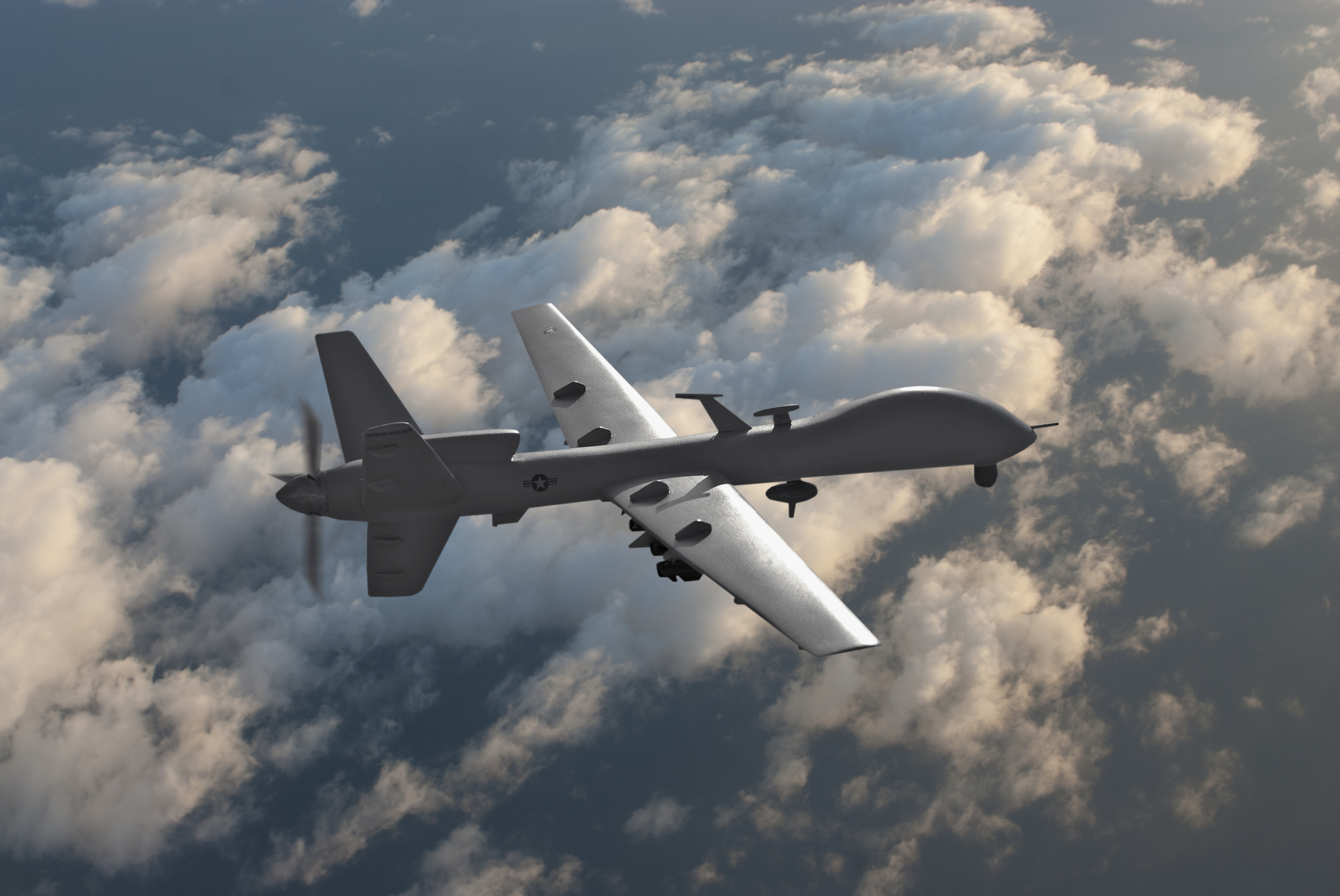 Military drone flying over the clouds.
