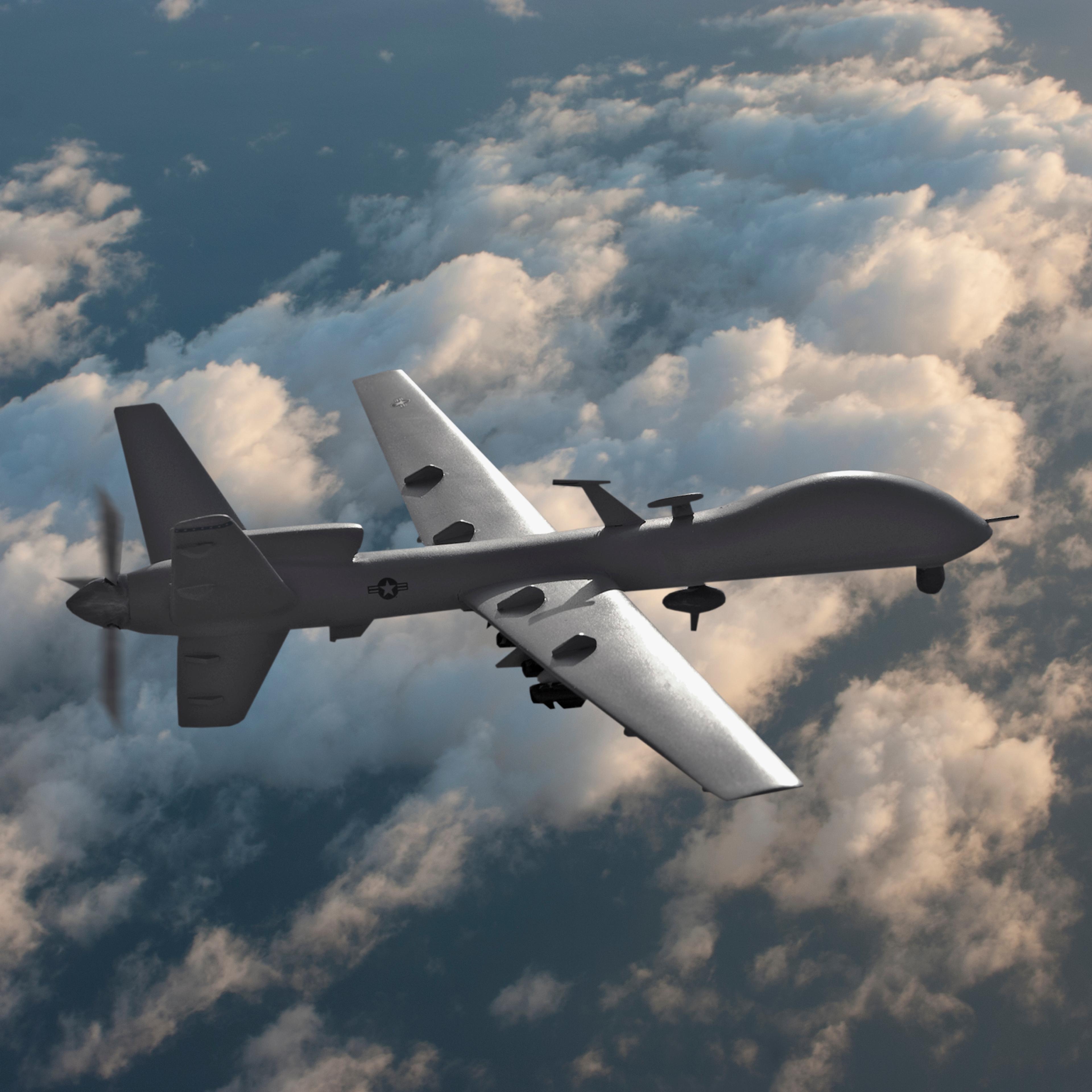 Military drone flying over the clouds.