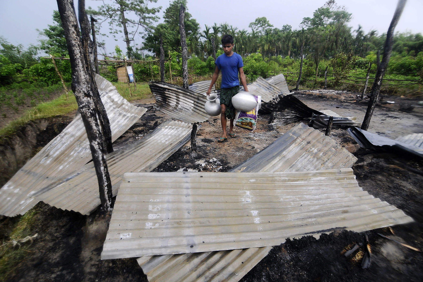 An Indian resident salvages valuables in the remains of his house in the village of Khagrabari, some 200 km west of Guwahati on May 3, 2014, after it was attacked by tribal separatists in India's remote northeastern state of Assam