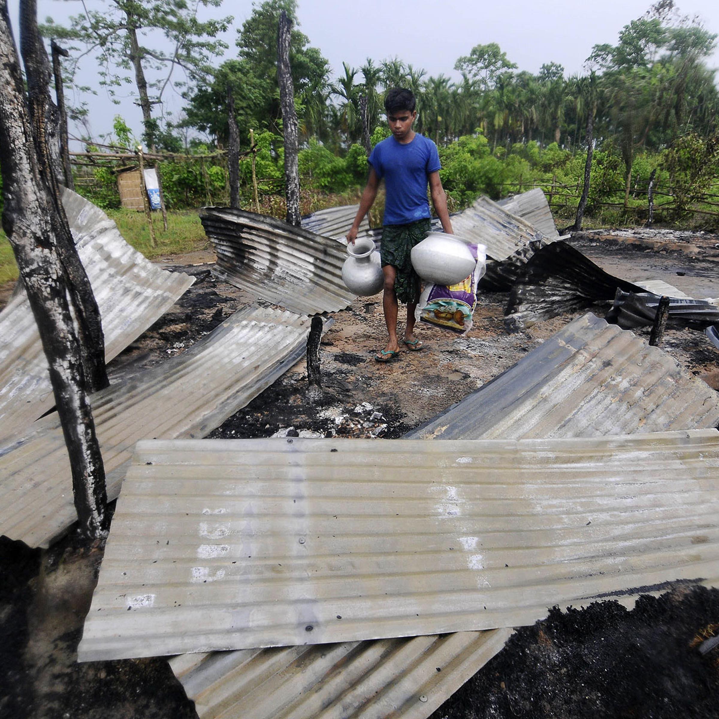 An Indian resident salvages valuables in the remains of his house in the village of Khagrabari, some 200 km west of Guwahati on May 3, 2014, after it was attacked by tribal separatists in India's remote northeastern state of Assam
