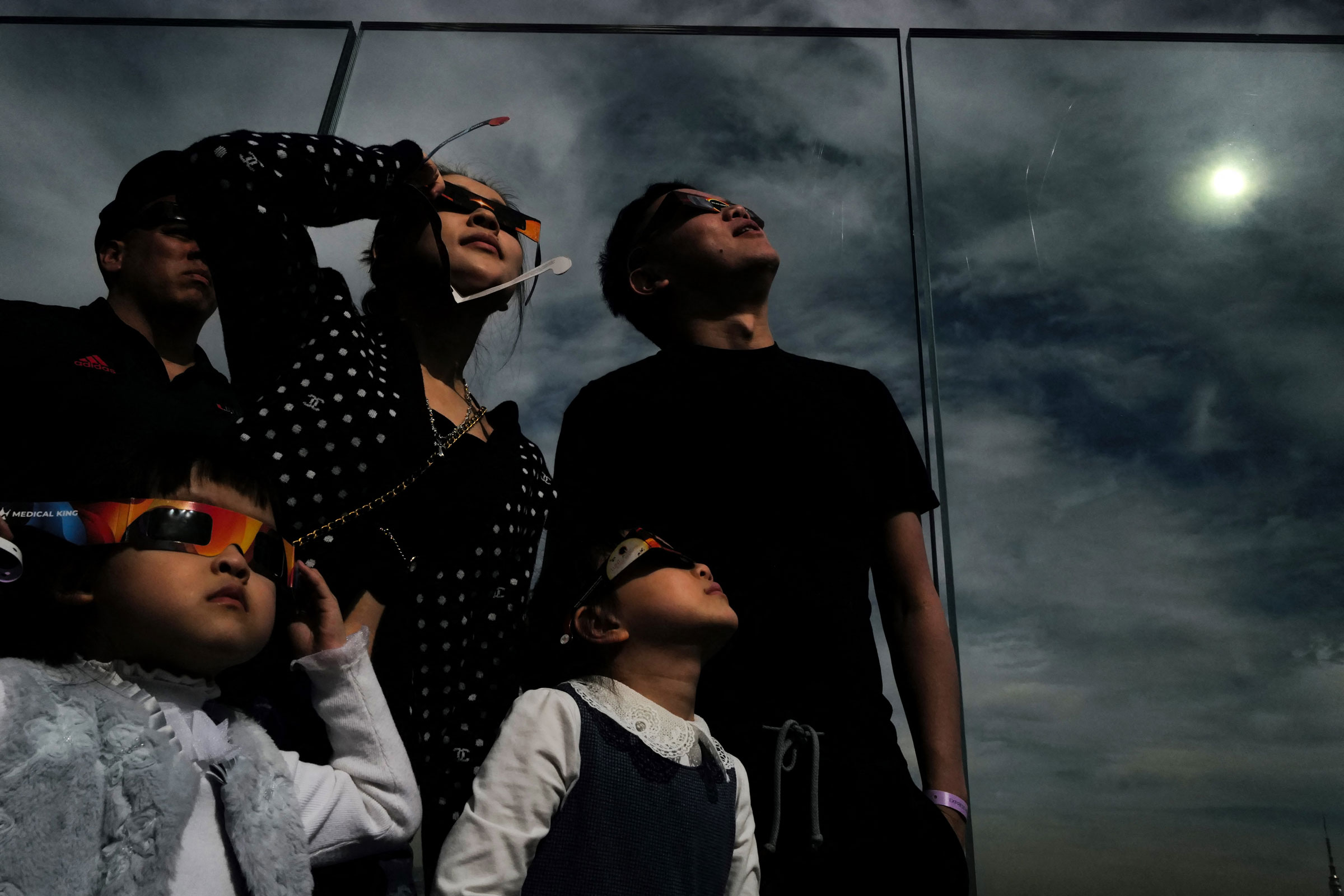 A woman looks toward the sky at the Edge at Hudson Yards observation deck during a solar eclipse, in New York City.