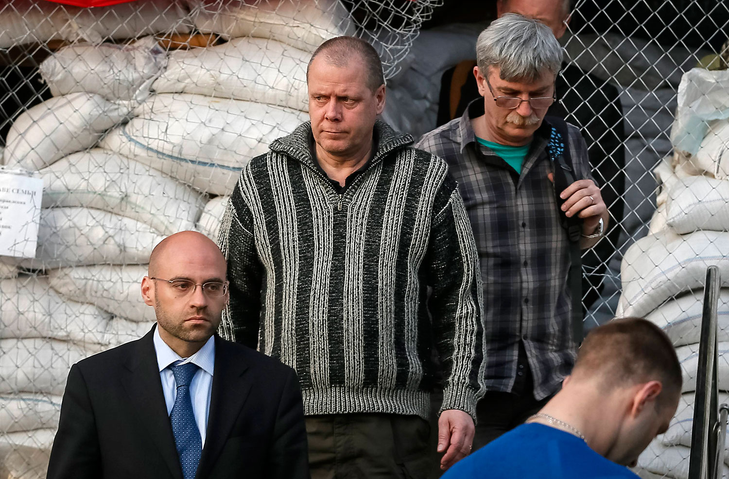 Officials from the OSCE special mission in Ukraine leave the mayor's office with a detained international observer, in Slaviansk