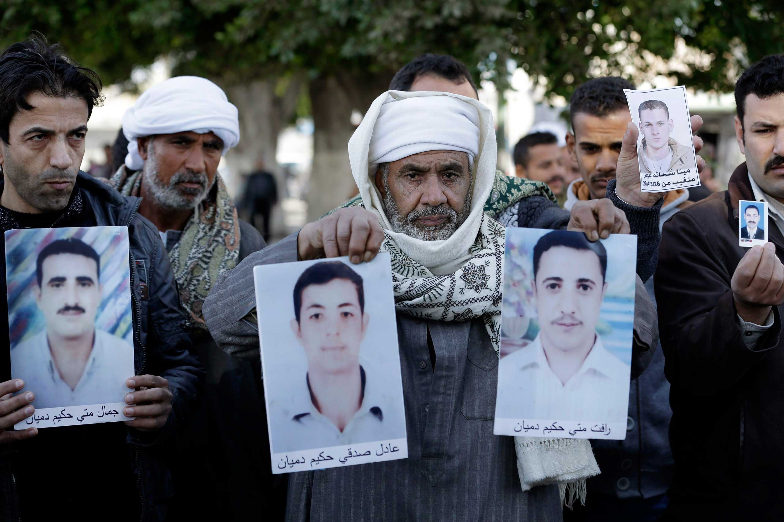 Coptic Christian men whose relatives were abducted in Libya hold their photos in front of the foreign ministry in Cairo, Jan. 19, 2015.
