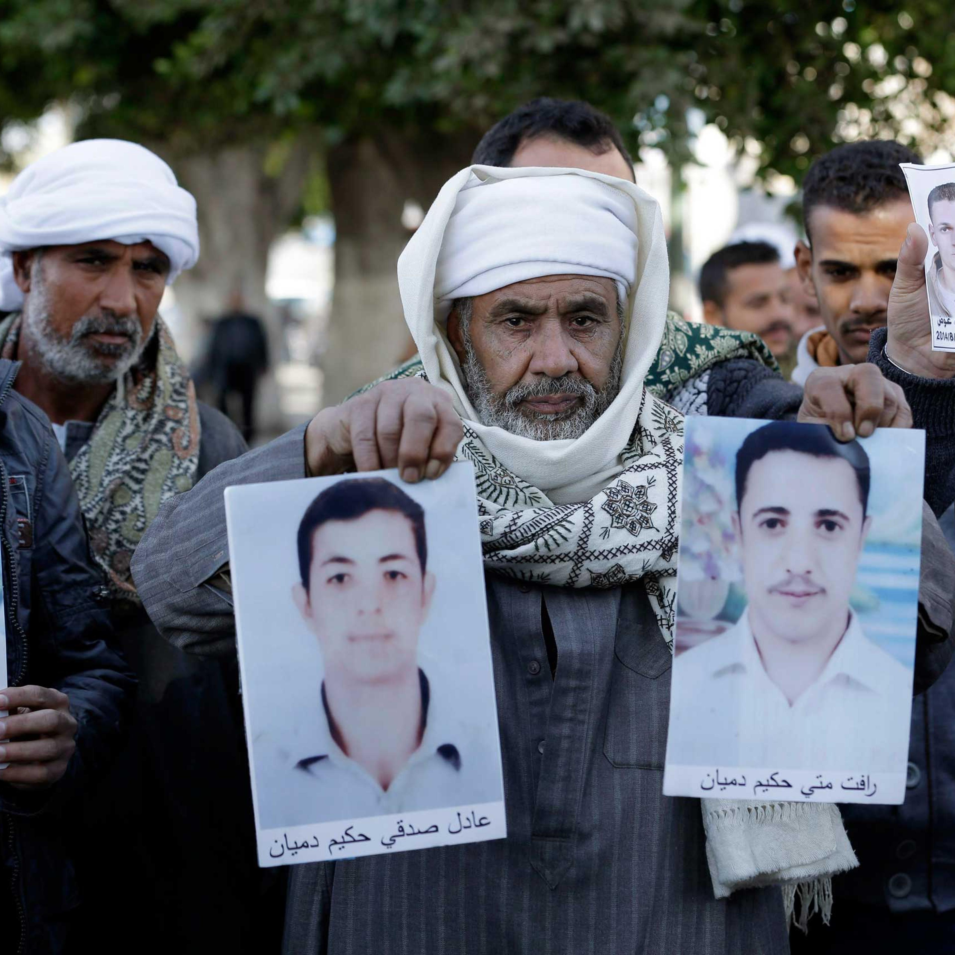 Coptic Christian men whose relatives were abducted in Libya hold their photos in front of the foreign ministry in Cairo, Jan. 19, 2015.