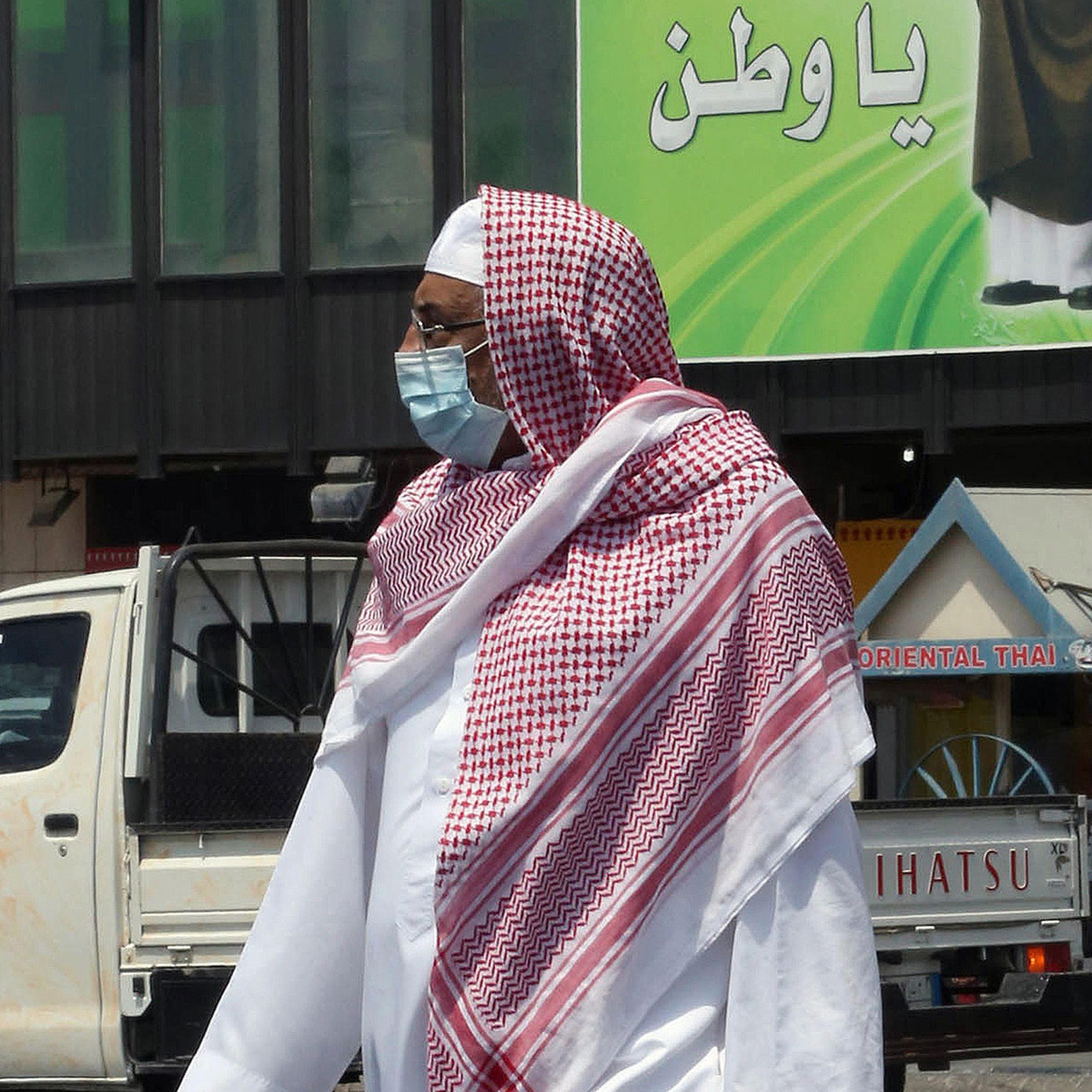 A Saudi man wears a mouth and nose mask as he walks in a street of the Red Sea coastal city of Jeddah on April 27, 2014