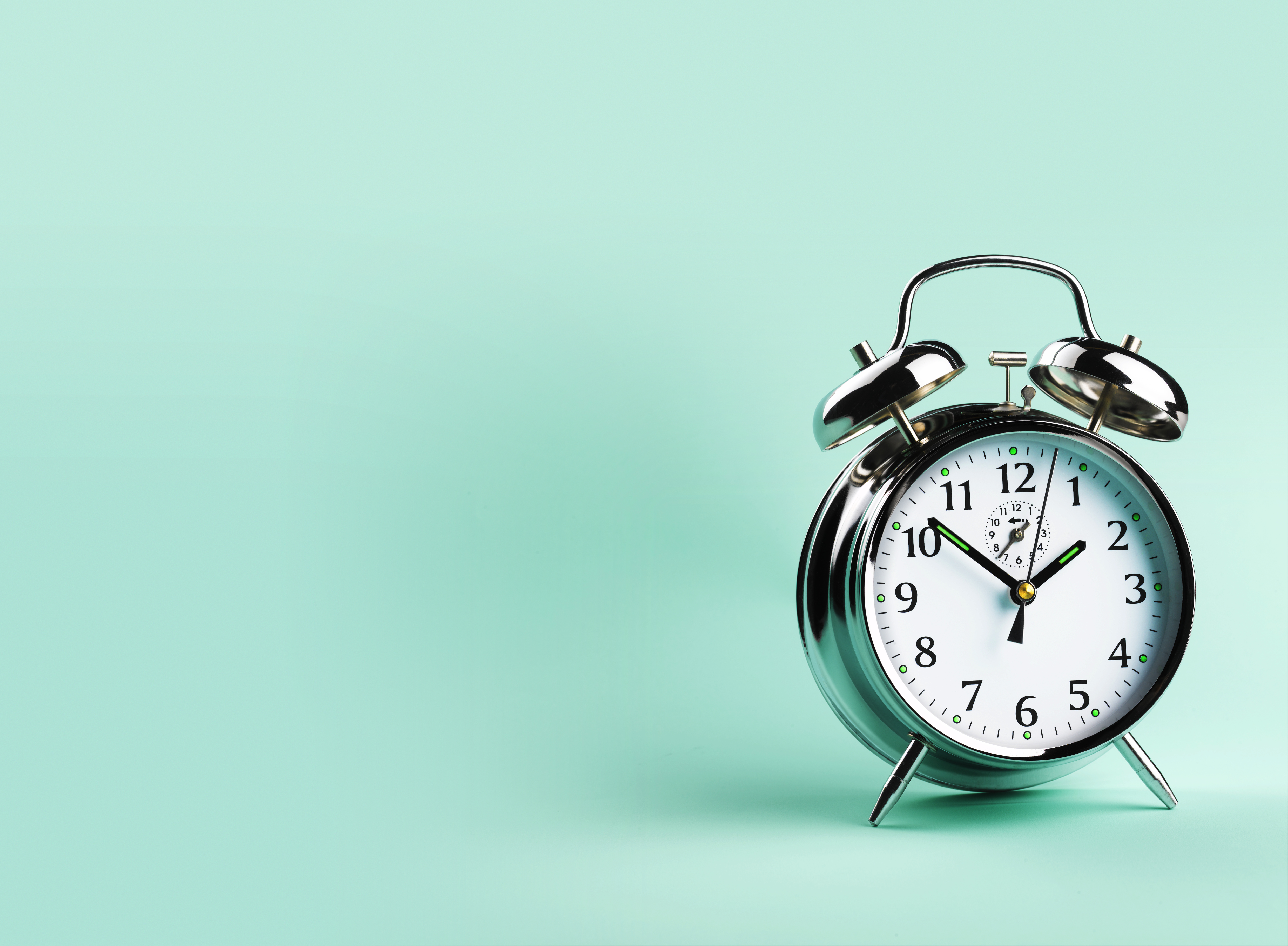 Alarm clock, against green background, close-up