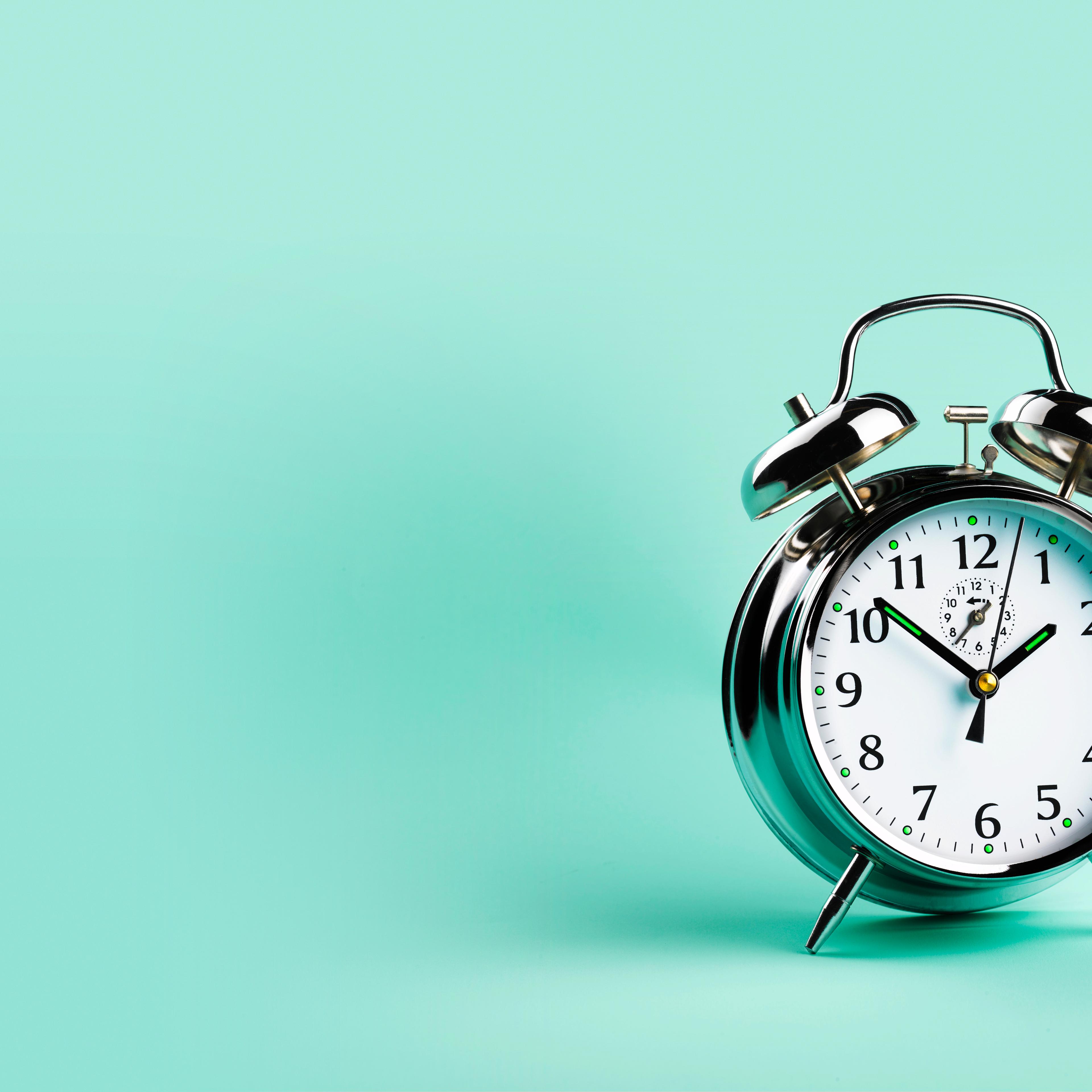 Alarm clock, against green background, close-up