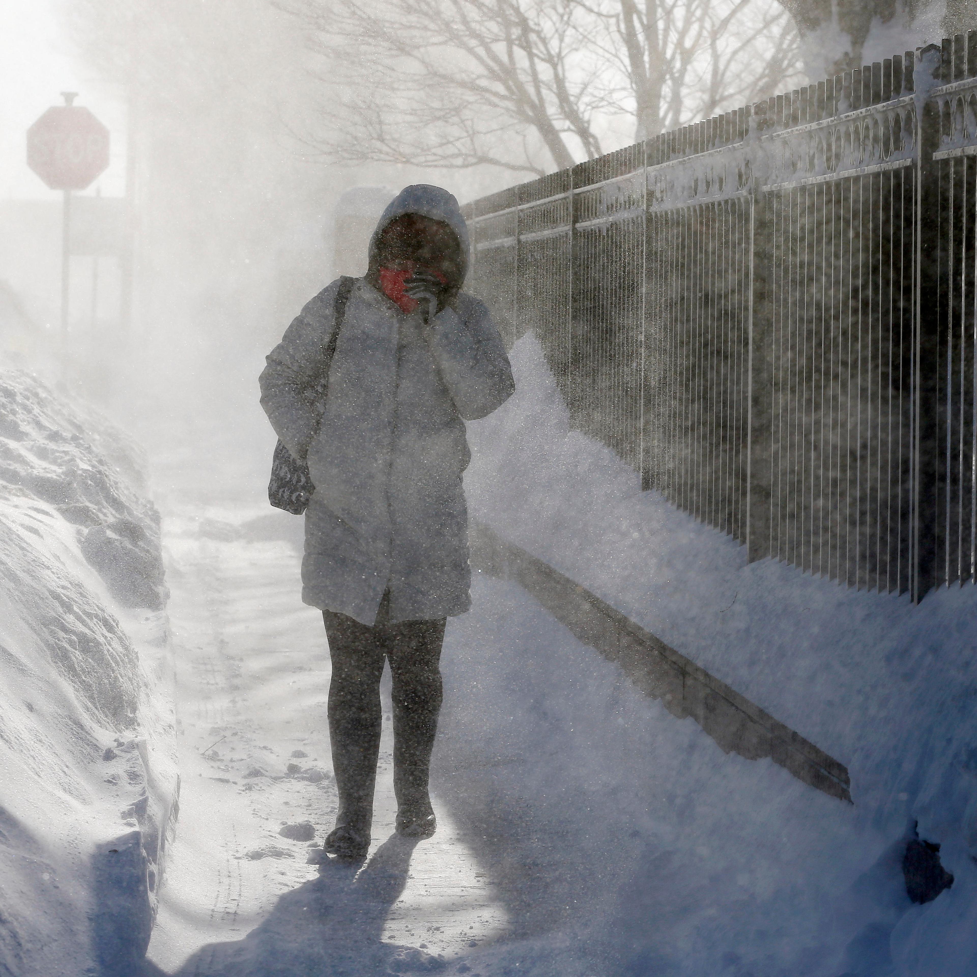 A woman walks through blowing snow in the East Boston neighborhood of Boston, Monday, Feb. 16, 2015