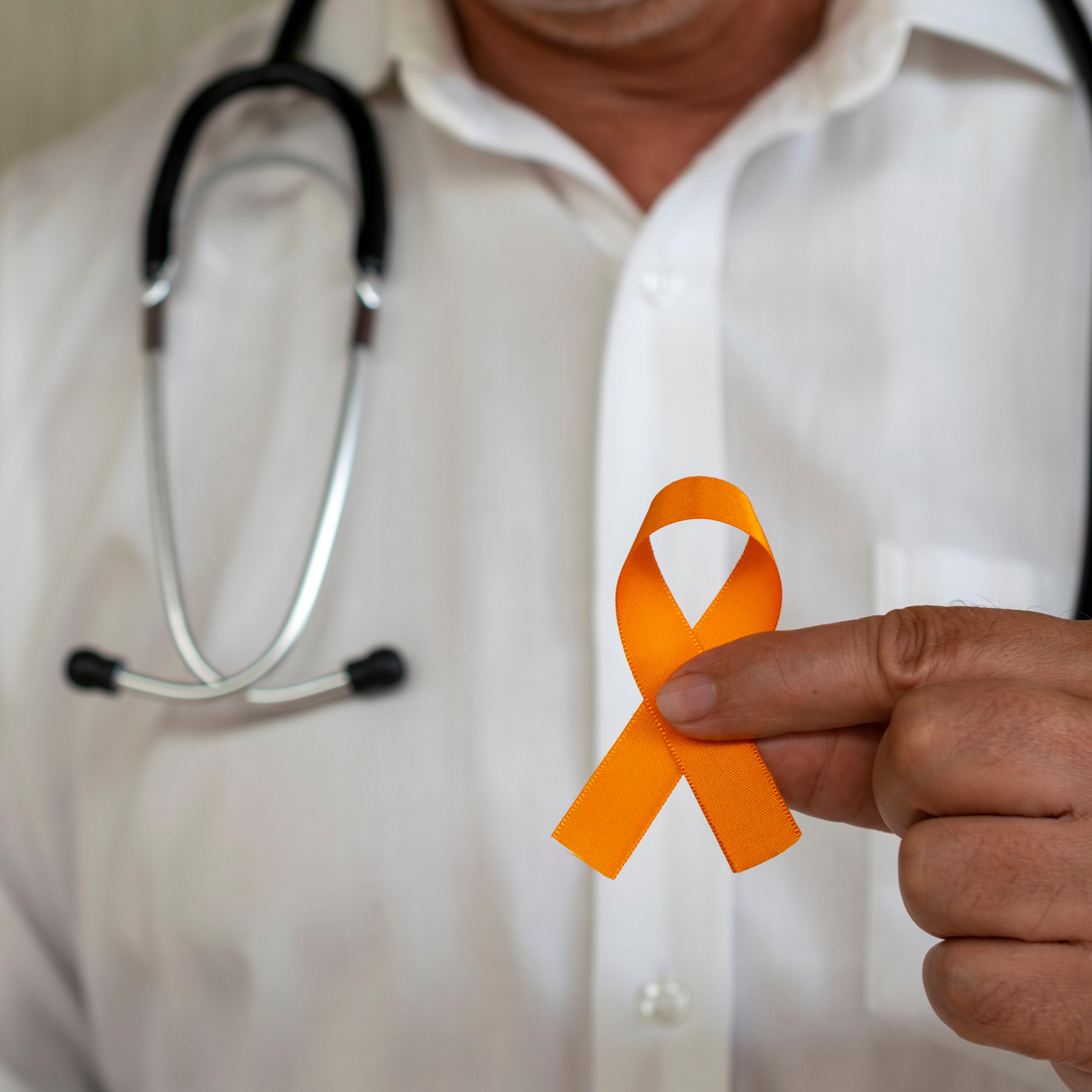 doctor holding orange ribbon. campaign to prevent skin cancer, melanoma, December orange