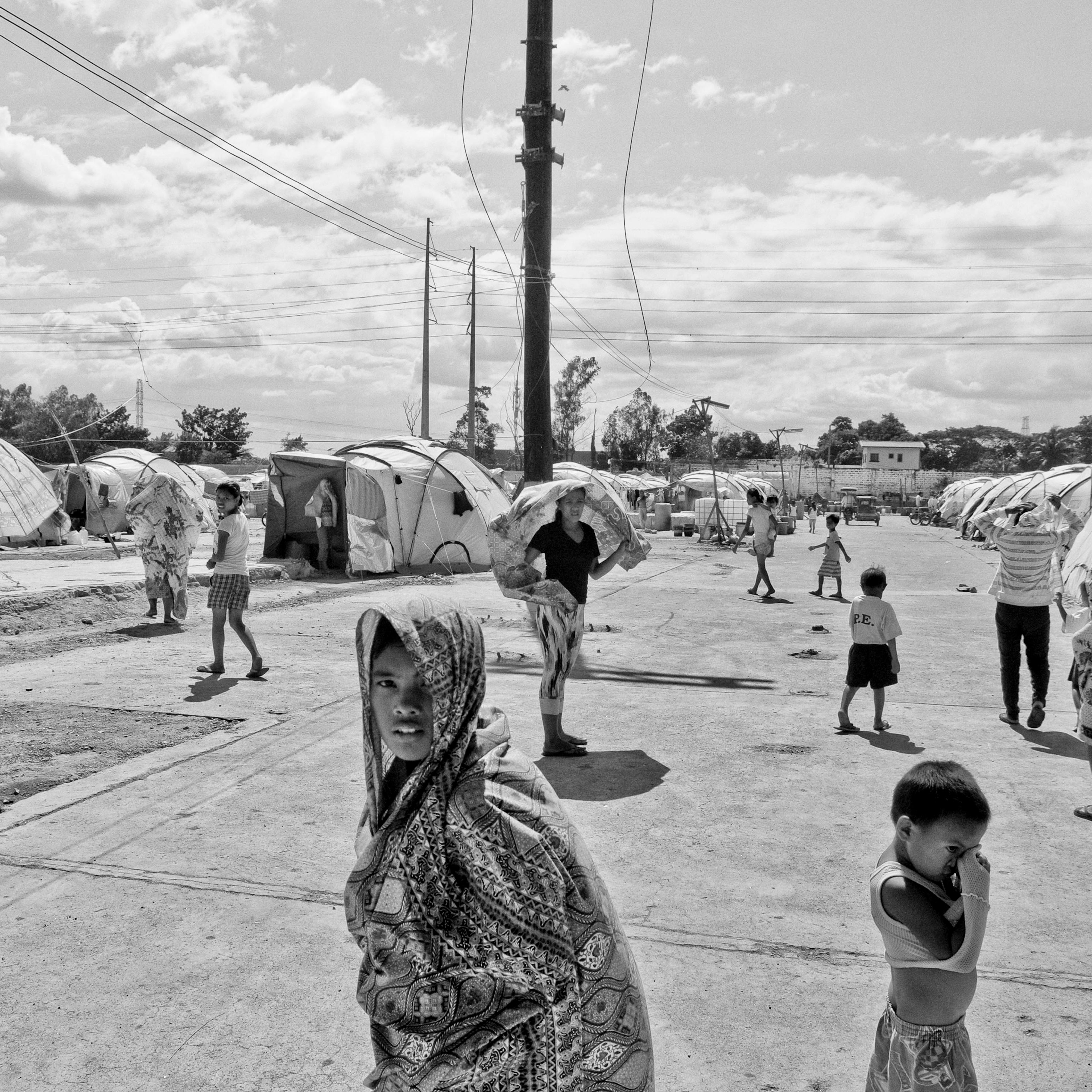 Families that have been displaced for several months due to stagnant floodwaters seek temporary shelter in a rundown factory on Oct. 23, 2012 in Laguna, Philippines.