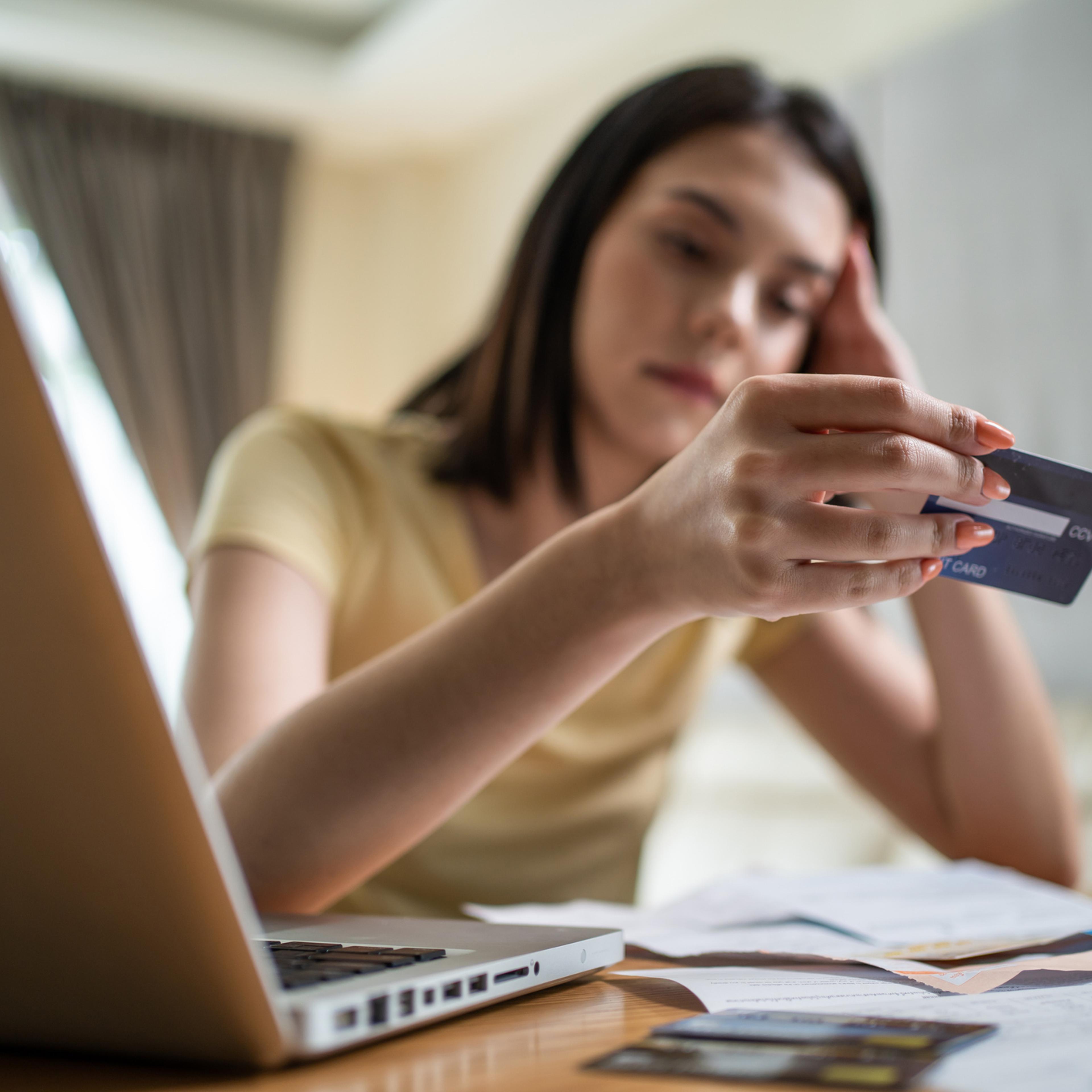 Depressed Asian young girl feel worry about financial problem in house. Stressed desperate young woman looking frustrated to paperwork and bills think of money debt, budget loss, bankruptcy at home.