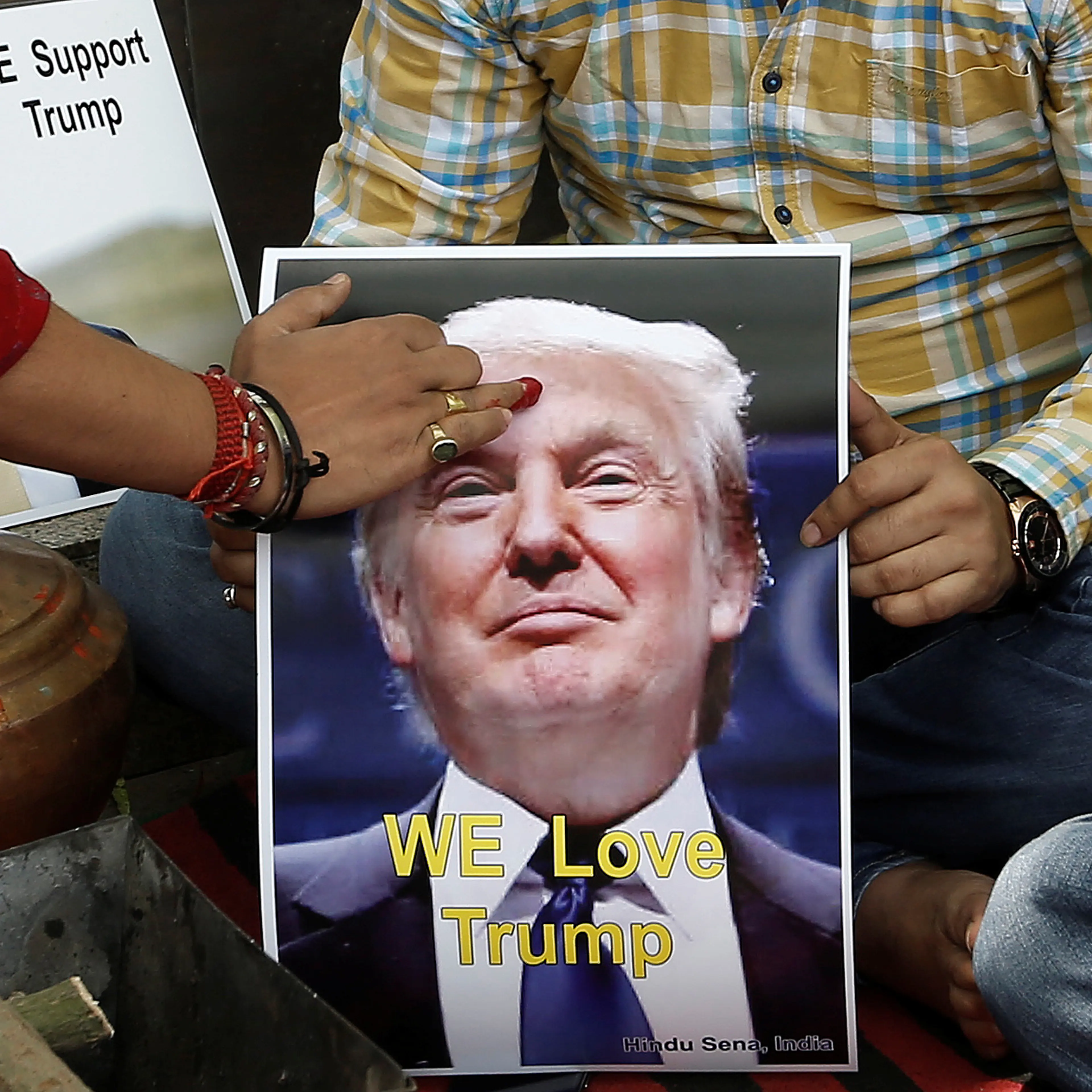 A priest applies a tika on the portrait of Republican U.S. presidential candidate Trump during a special prayer to ensure his victory in New Delhi
