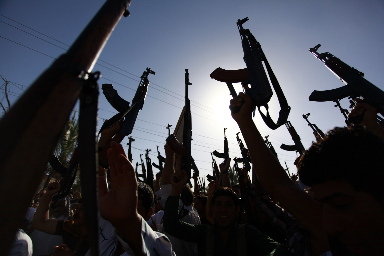 Iraqi Shiite tribesmen brandish their weapons as they gather to show their willingness to join Iraqi security forces in the fight against Jihadist militants who have taken over several northern Iraqi cities, on June 17 2014, in the southern Shiite Muslim