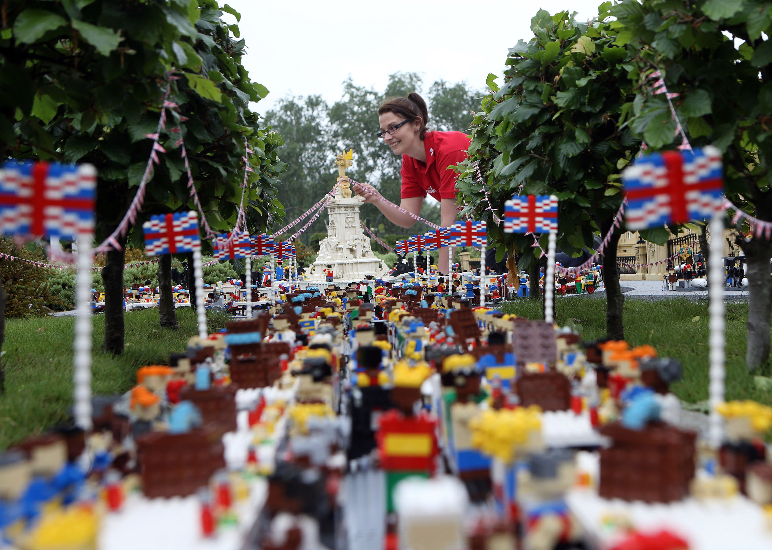 Legoland Windsor Resort model maker Kat James puts the finishing touches to a miniature street party outside a model of Buckingham Palace in Miniland ahead of the Patron's Lunch on The Mall in London to mark the Queen's official 90th birthday, June 8, 20
