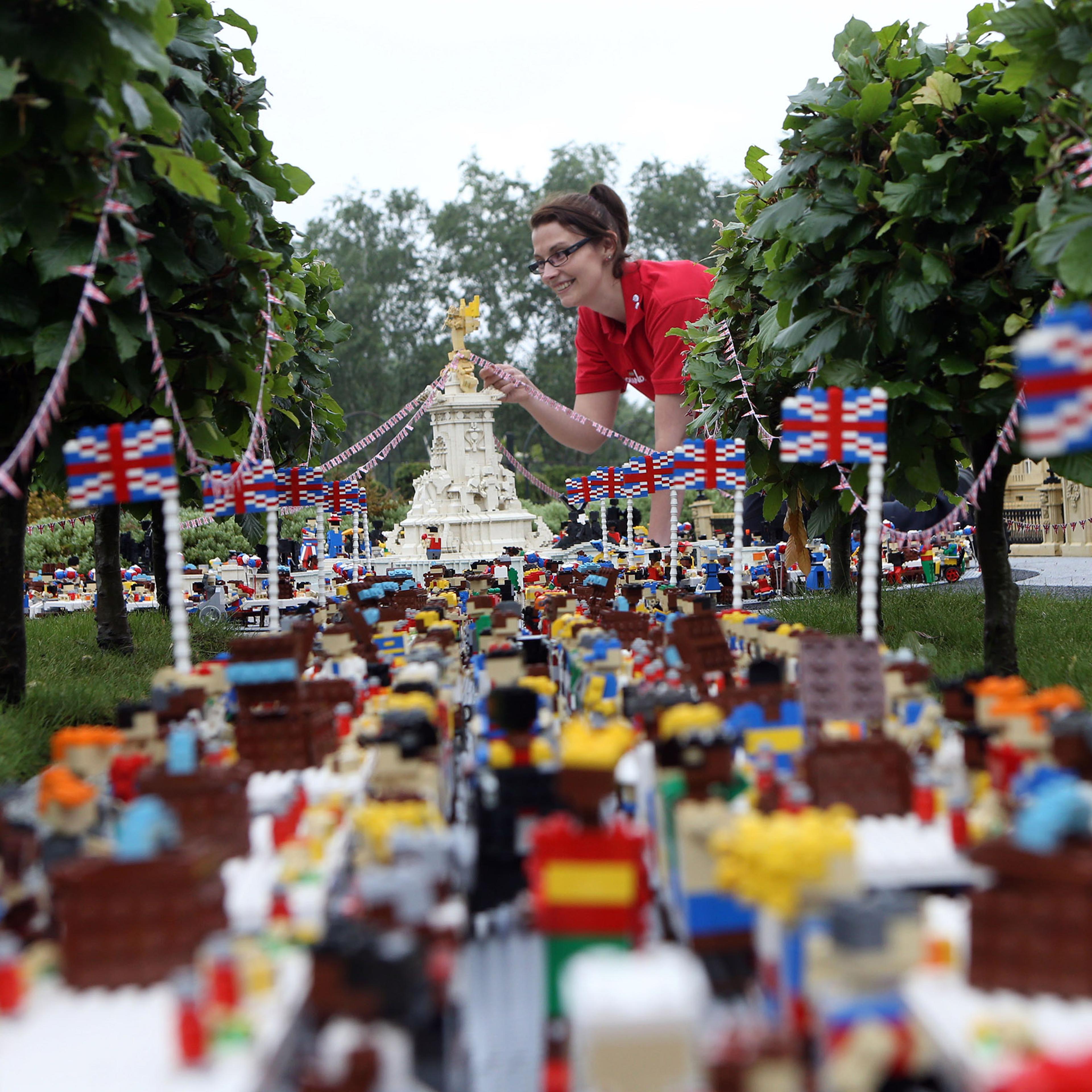Legoland Windsor Resort model maker Kat James puts the finishing touches to a miniature street party outside a model of Buckingham Palace in Miniland ahead of the Patron's Lunch on The Mall in London to mark the Queen's official 90th birthday, June 8, 20