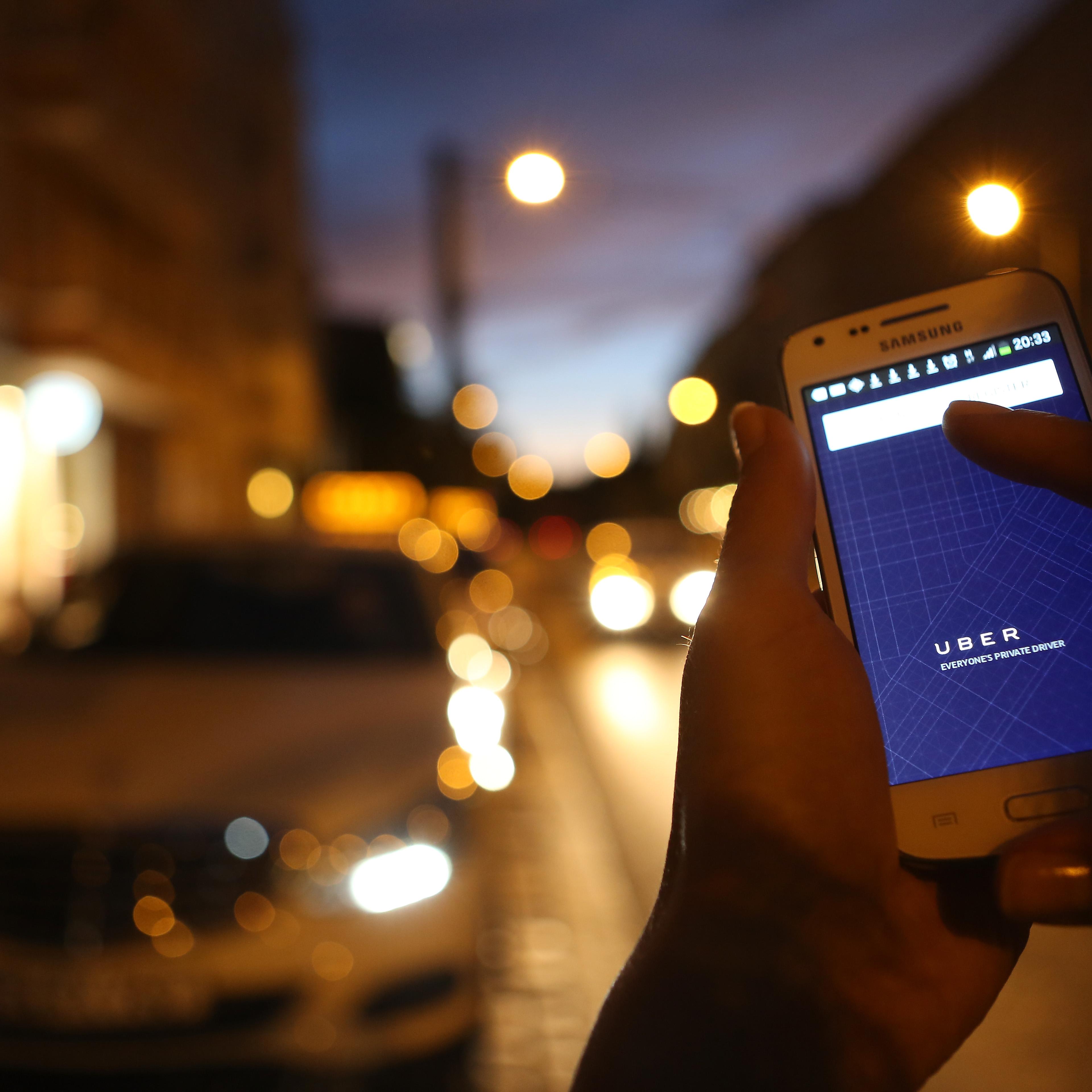 In this photo illustration, a woman uses the Uber app on an Samsung smartphone on September 2, 2014 in Berlin, Germany.