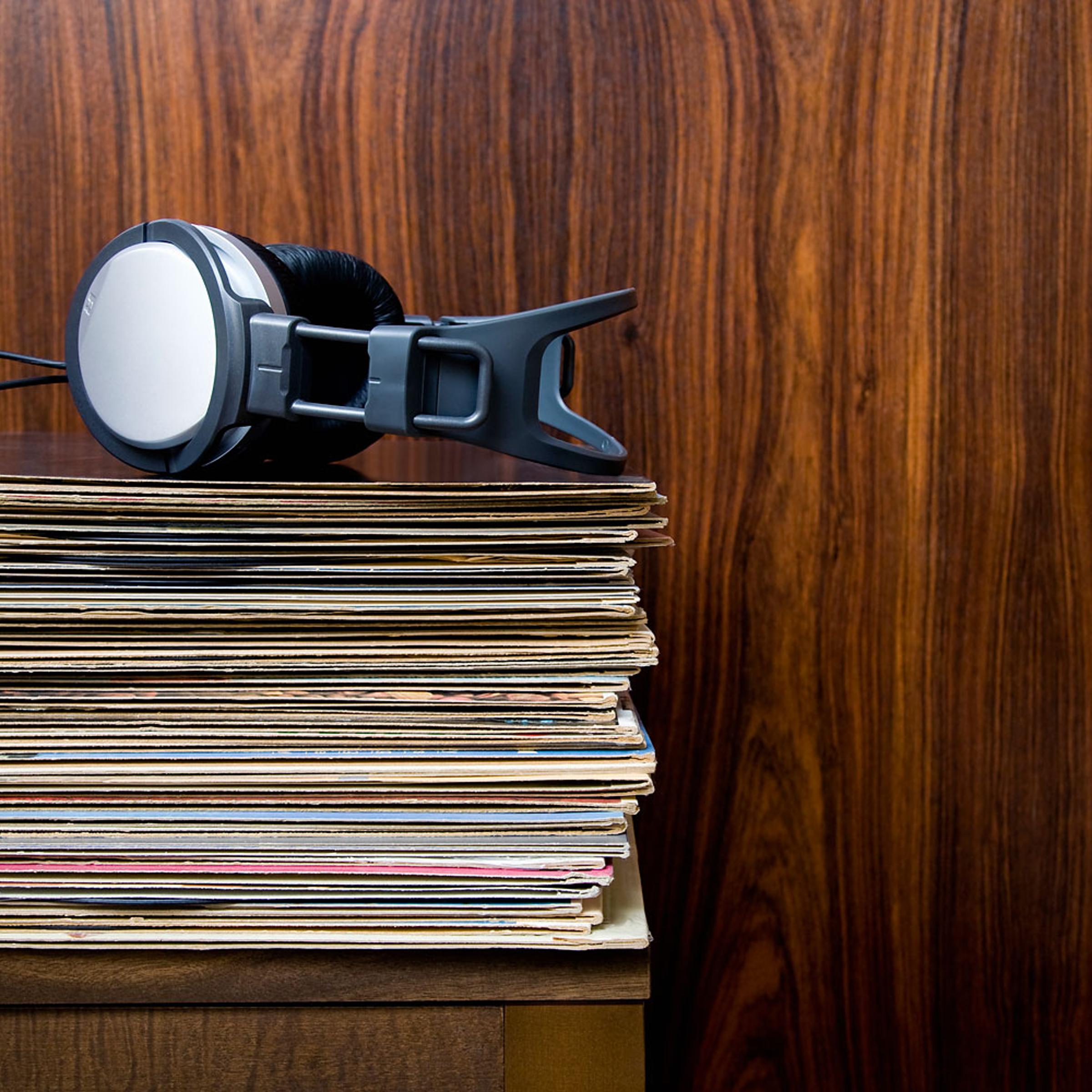 Headphones laying on stack of vinyl records