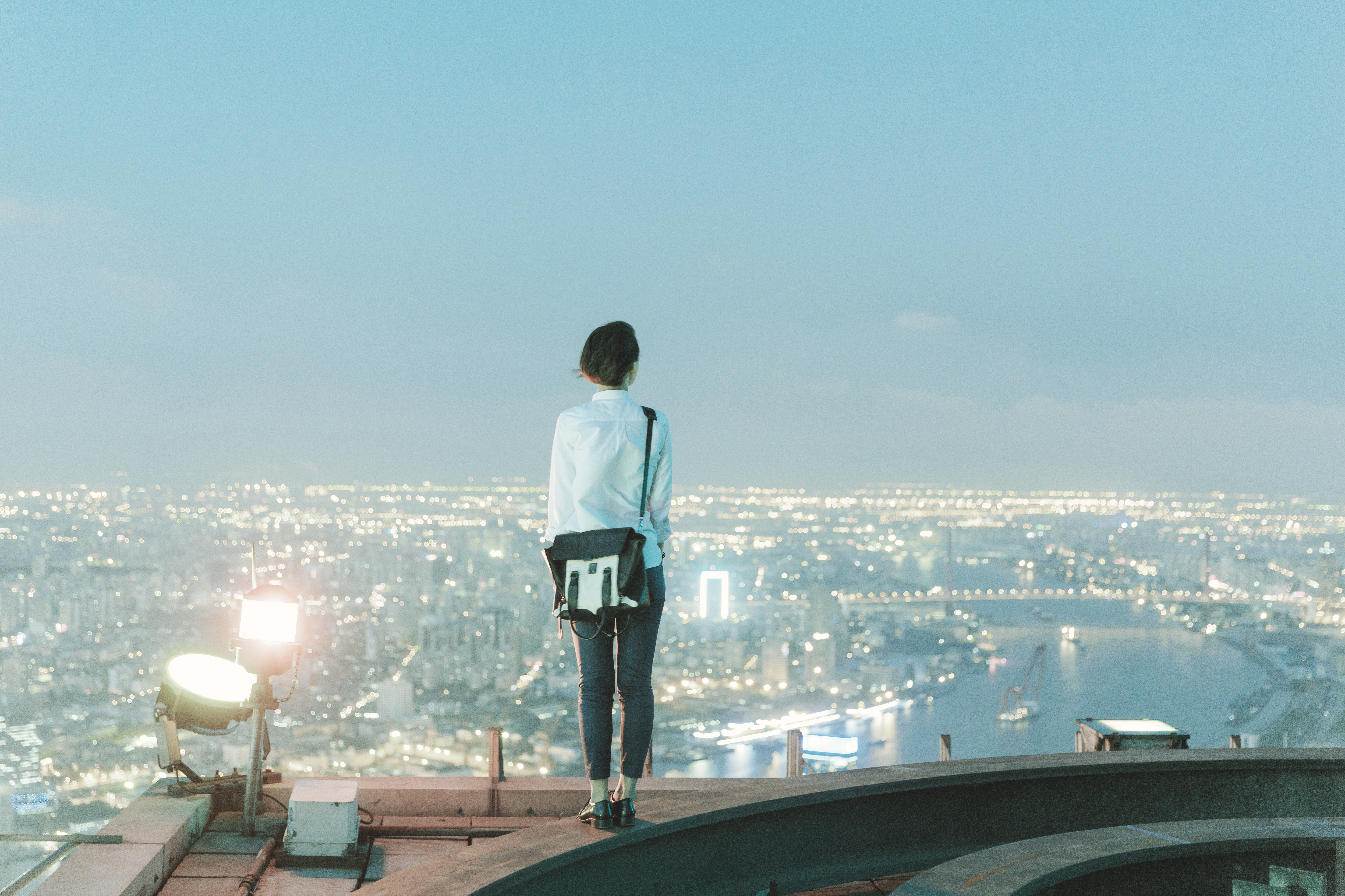 woman-standing-rooftop-rear-view-city