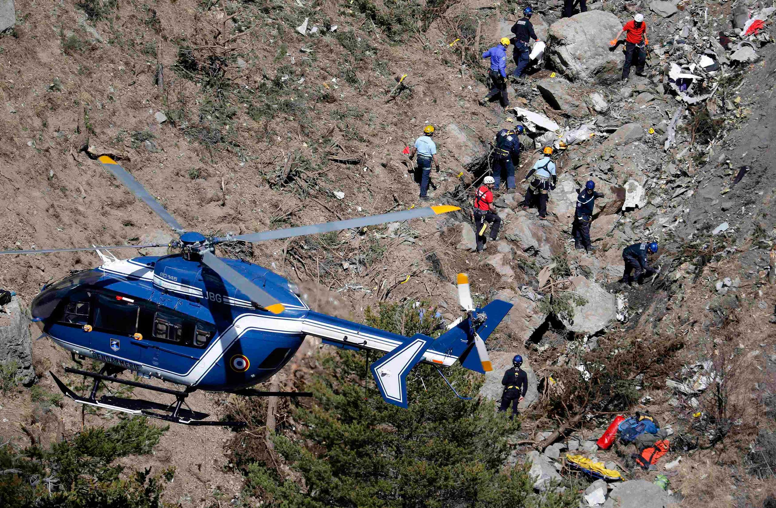 French gendarmes and investigators work amongst the debris of the Airbus A320 at the site of the crash, near Seyne-les-Alpes, in the French Alps, on March 26, 2015.