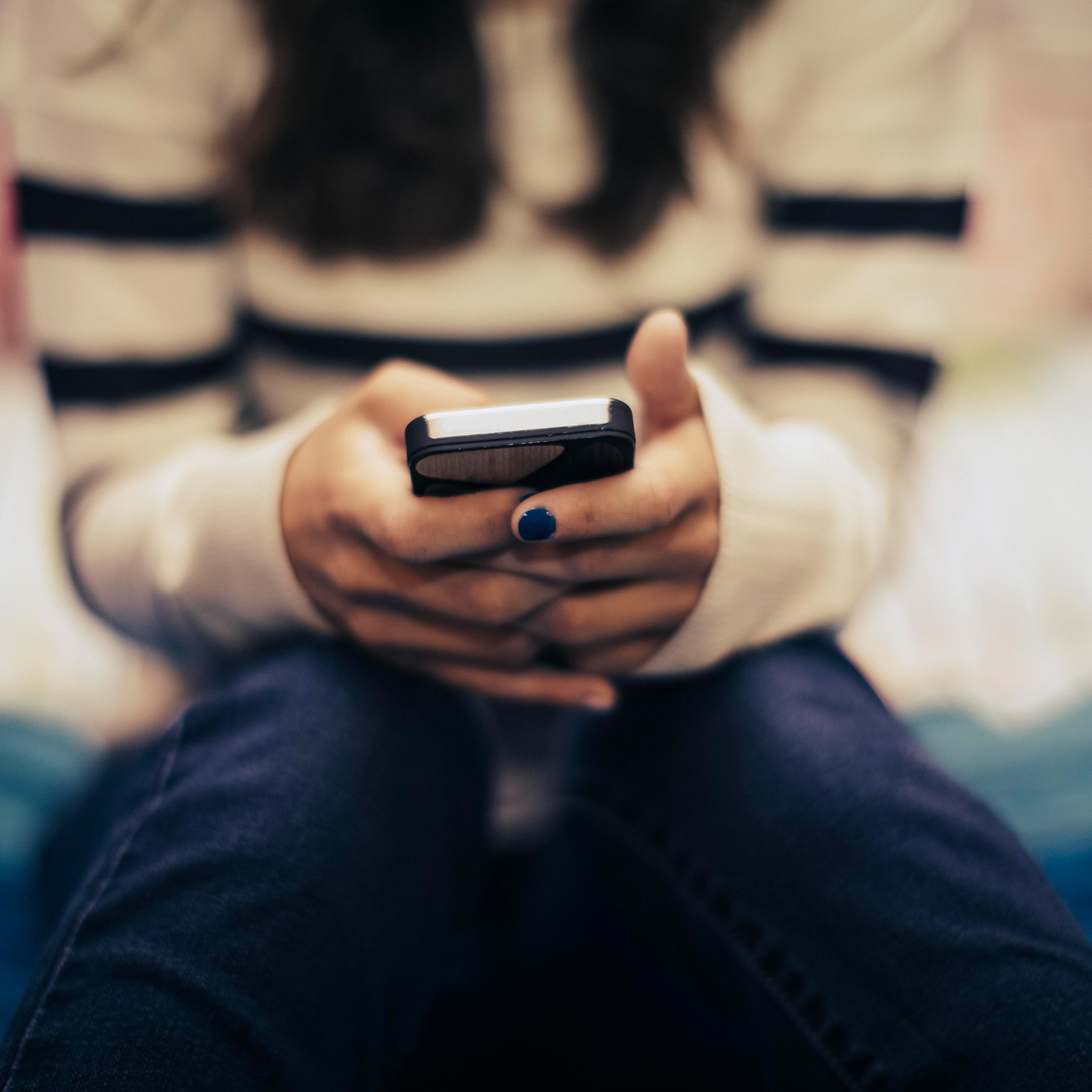Close up of teenage girl in bedroom using smart phone