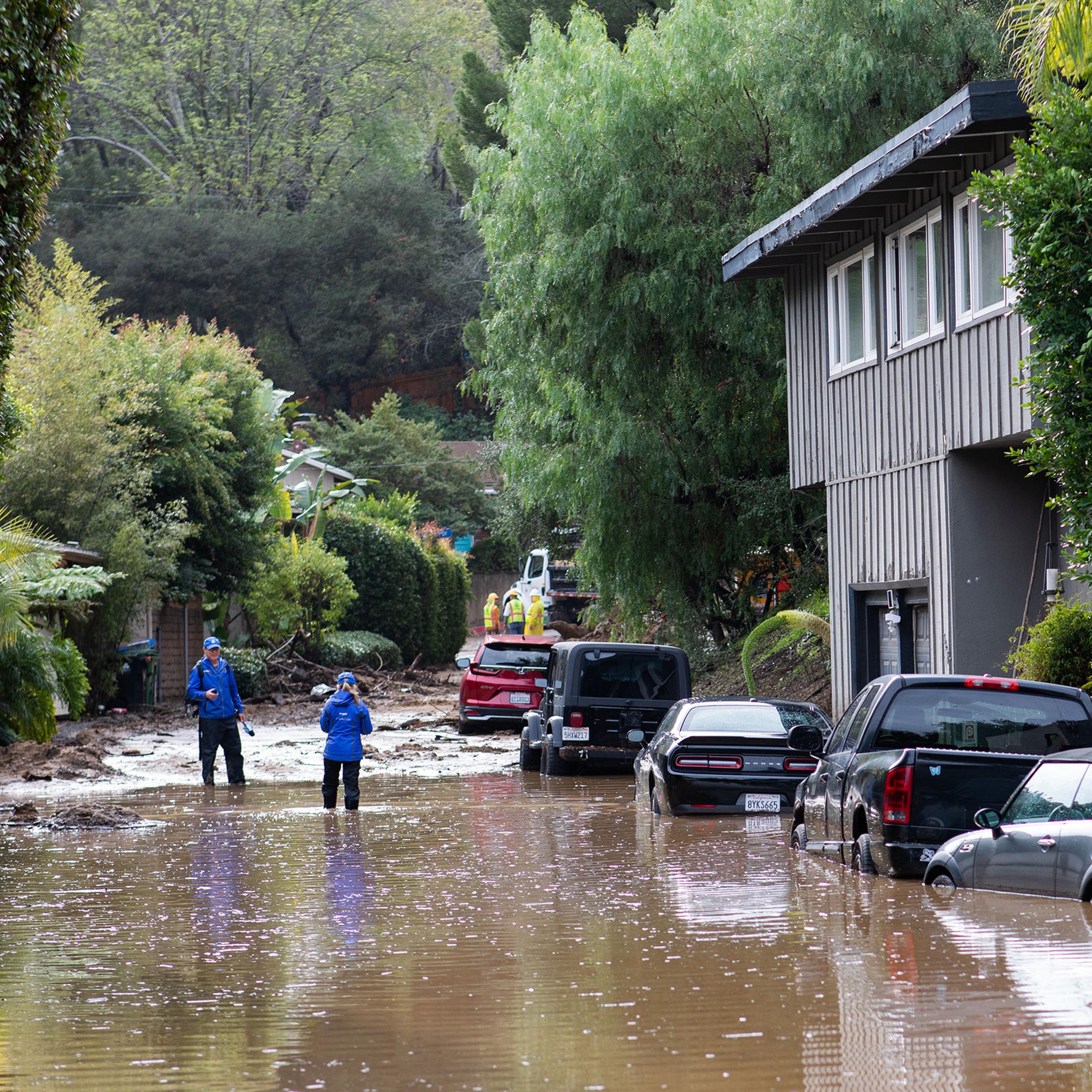 STUDIO CITY, CALIFORNIA - January 10th, 2023: News reporters at a flooded block in a Studio City neighborhood on Tuesday..CREDIT: Alex Welsh for TIME