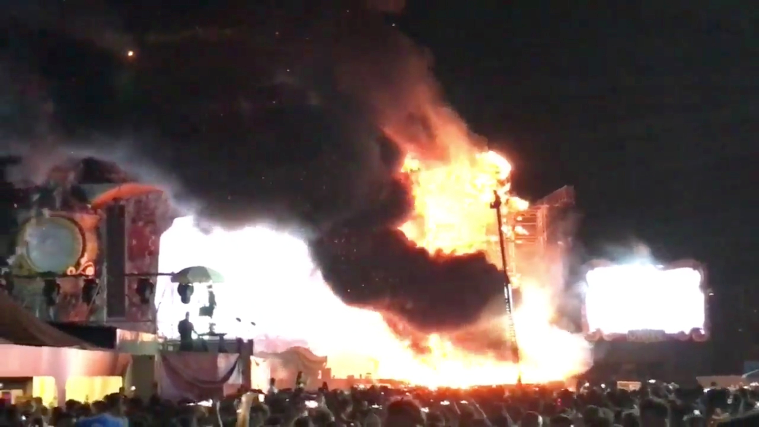 Smoke is seen rising from flames engulfing the stage after a fire broke out at Tomorrowland Unite Spain festival in Barcelona