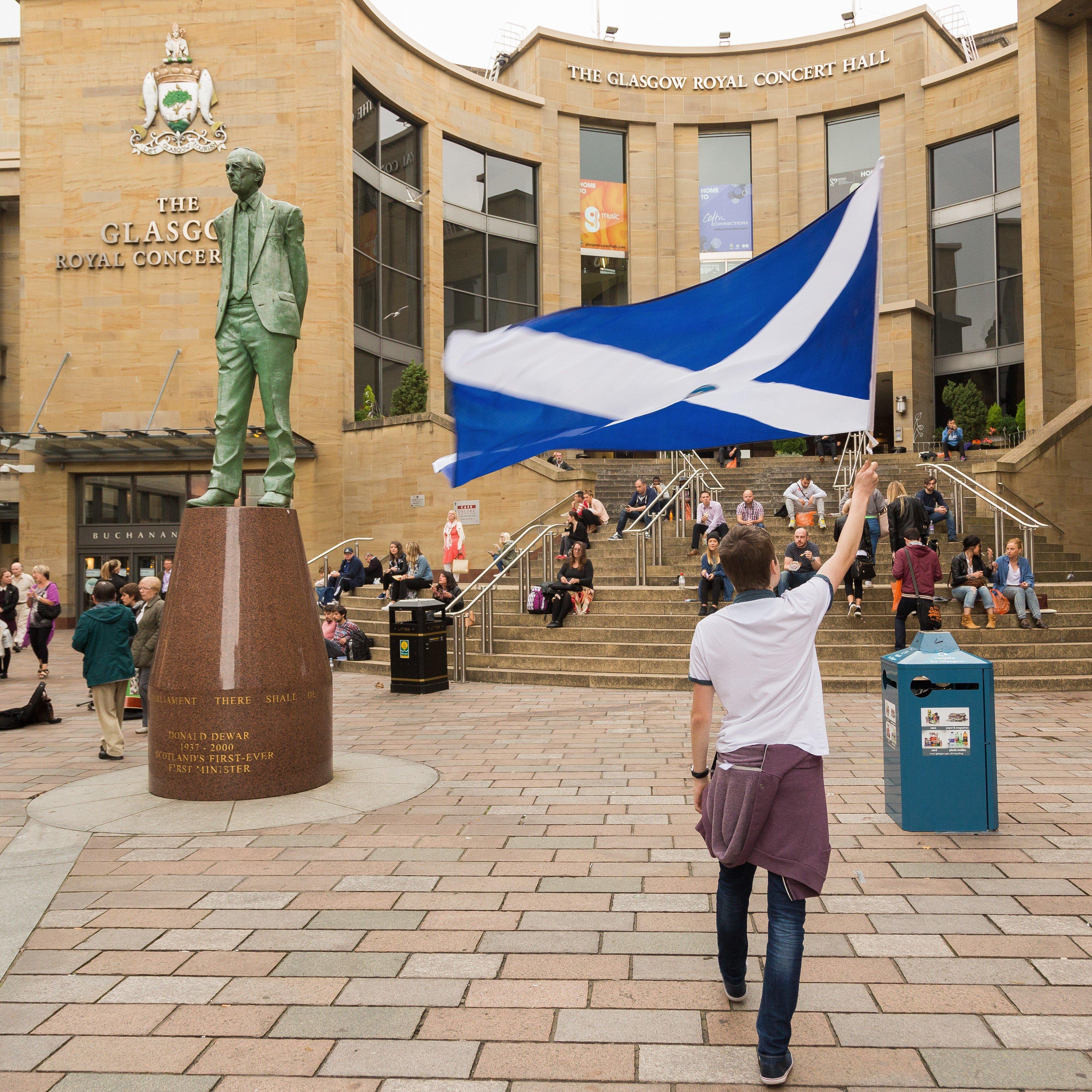 A Yes campaign supporter flies a large Scotland flag close to the statue of Donald Dewar in Buchanan Street on Sept. 4, 2014.