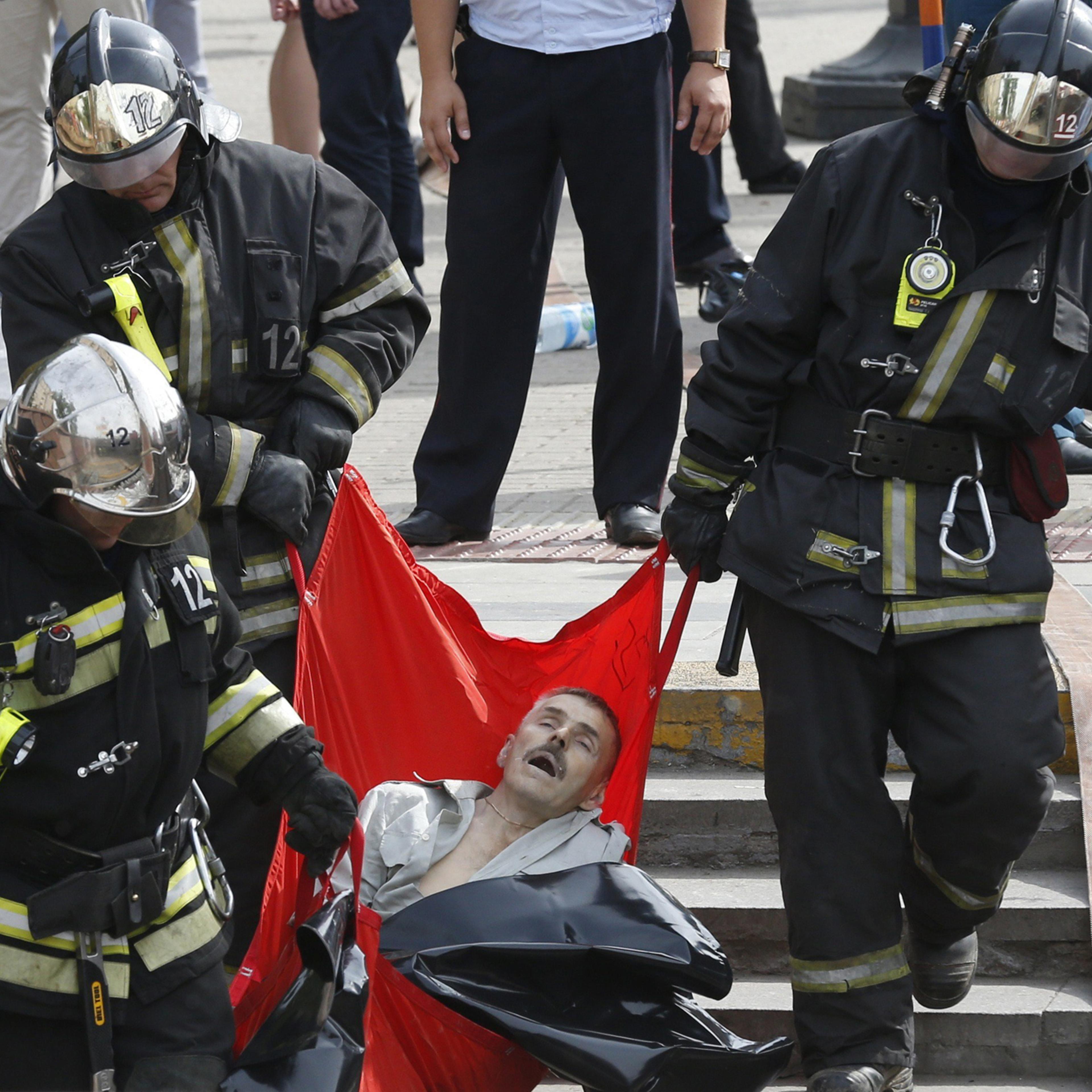 Rescuers carry a passenger injured as several subway cars derailed in Moscow, on July 15, 2014.