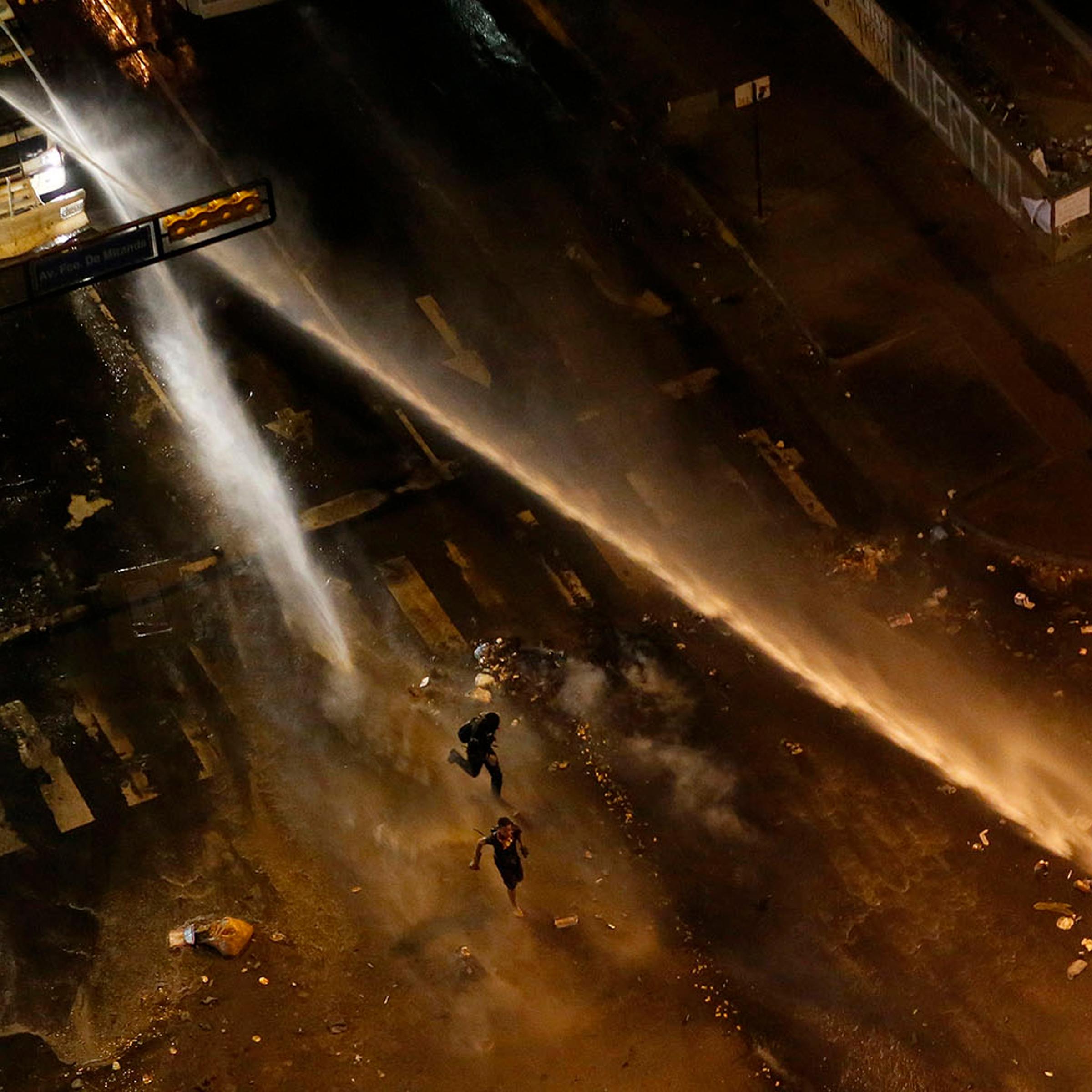 The national guard disperses water cannons on anti-government protesters during a protest at Altamira square in Caracas