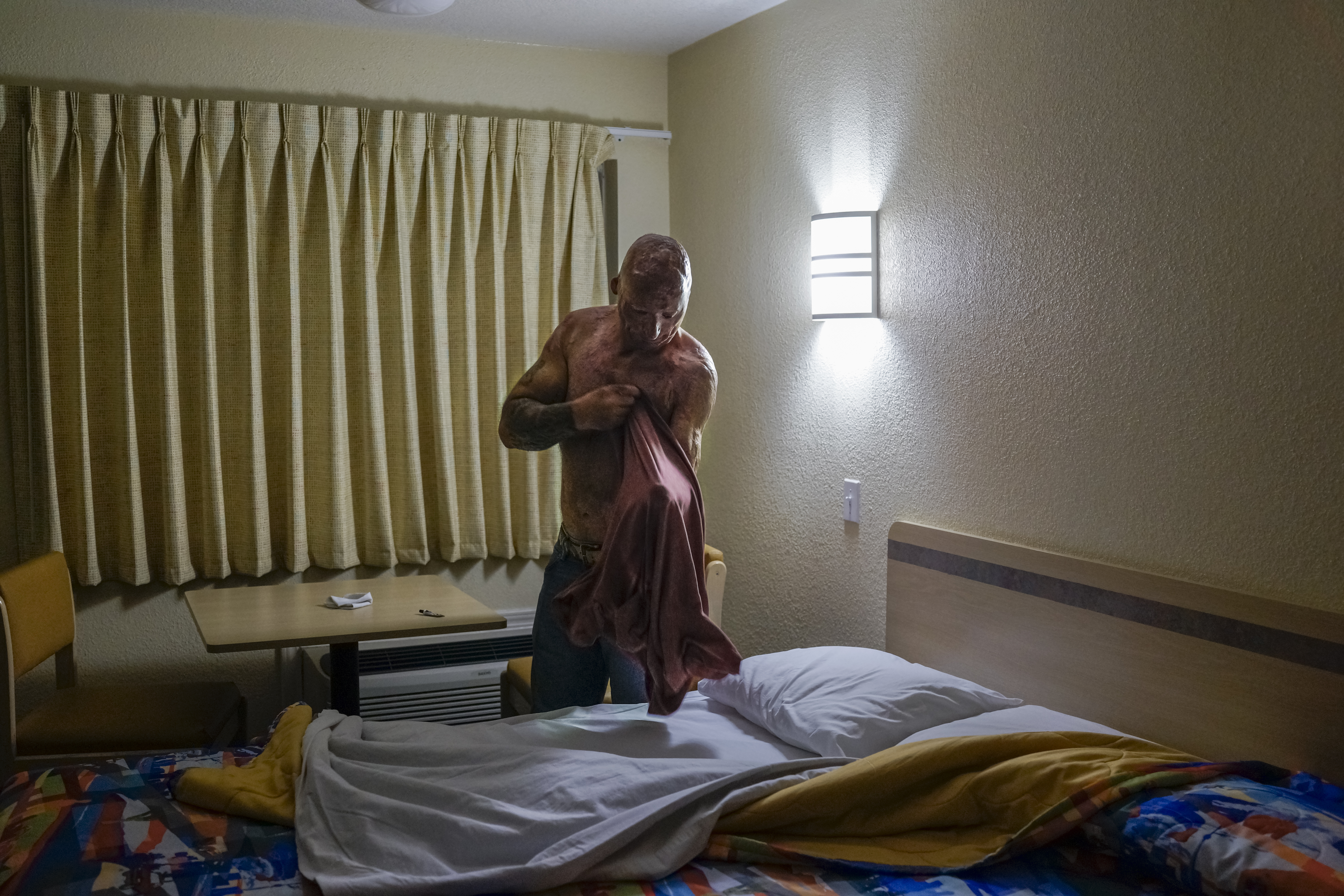 2013. Humble, TX. USA. Bobby gets ready for bed at a Motel 6. Bobby Henline, 41, veteran of four tours to Iraq and sole survivor of an IED blast that killed the other four soldiers in his humvee in Iraq in 2007. He is now a standup comedian launching a n