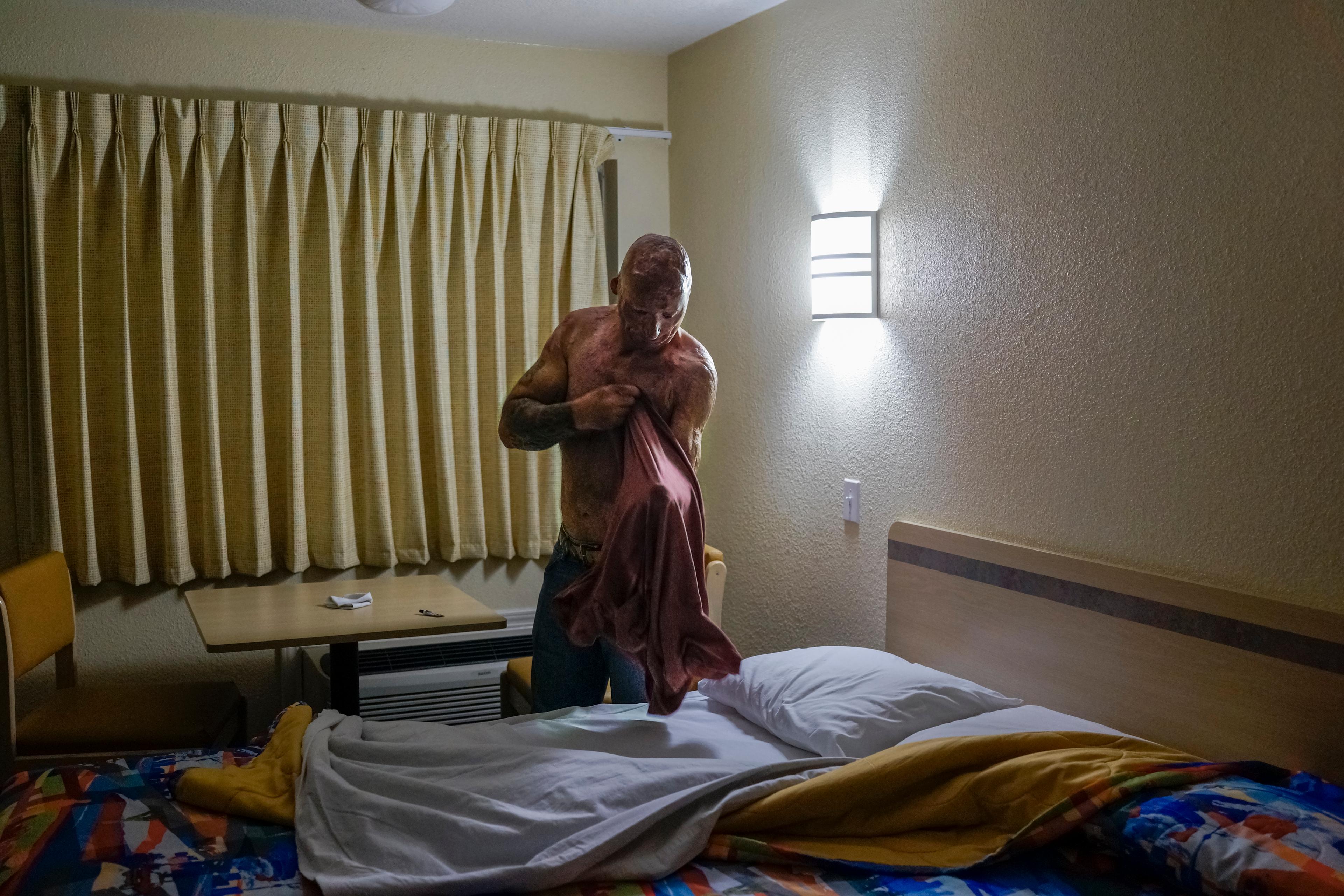 2013. Humble, TX. USA. Bobby gets ready for bed at a Motel 6. Bobby Henline, 41, veteran of four tours to Iraq and sole survivor of an IED blast that killed the other four soldiers in his humvee in Iraq in 2007. He is now a standup comedian launching a n