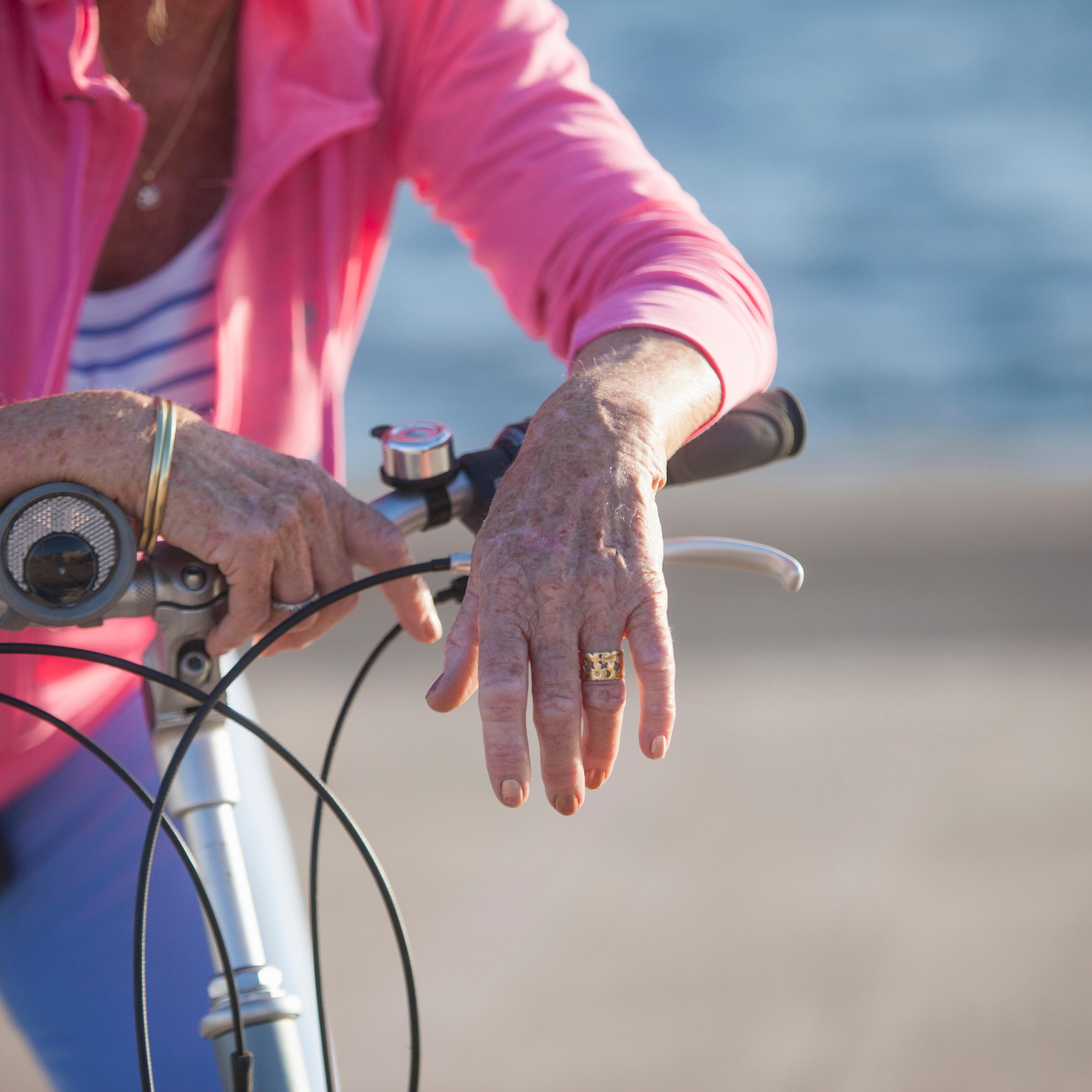 Senior woman on bicycle by beach