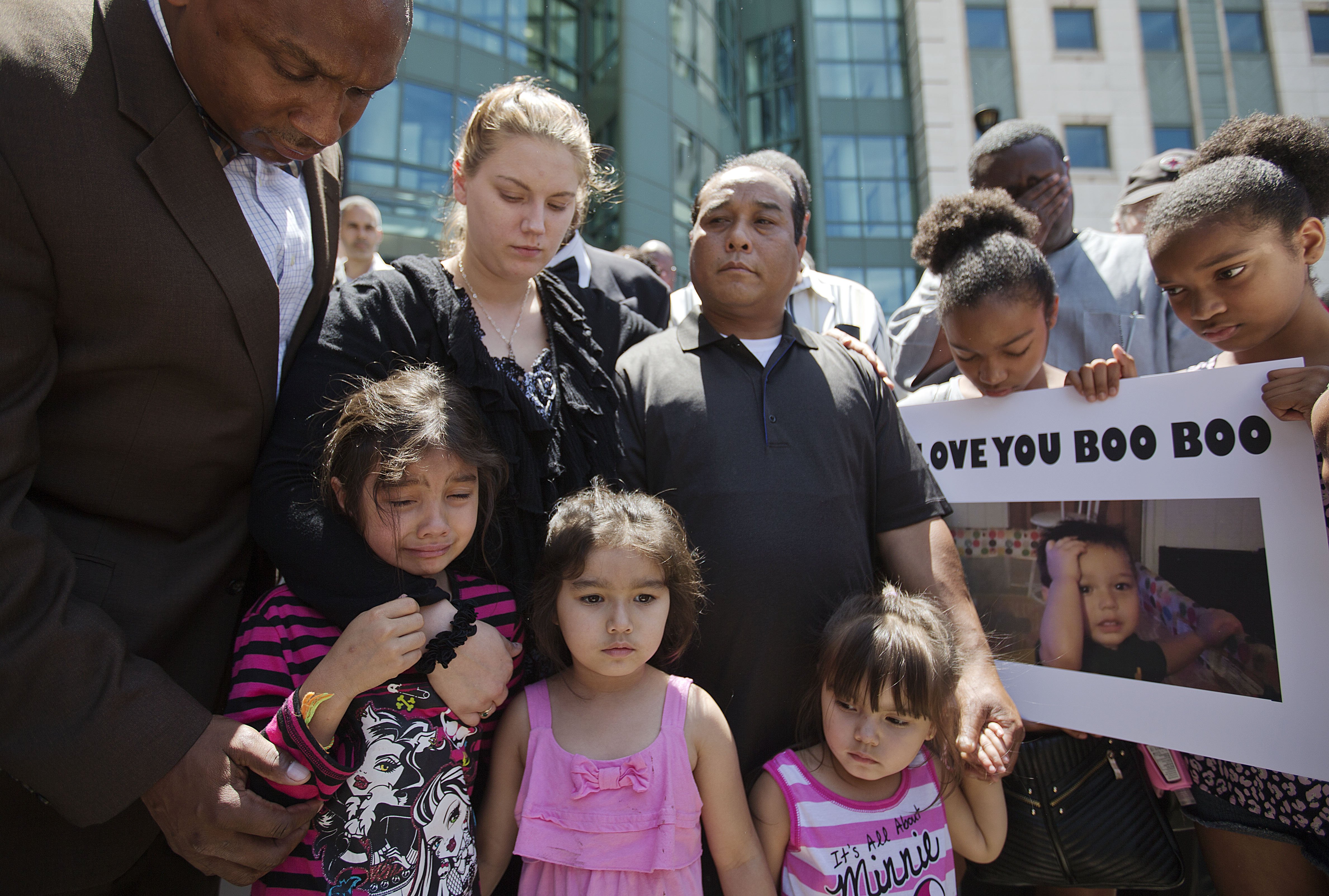 Alecia and Boun Khan Phonesavanh (center), the parents of 19-month-old Bounkham Phonesavanh who was severely burned by a flash grenade during a SWAT drug raid, attend a vigil with their daughters outside Grady Memorial Hospital where he is undergoing tre