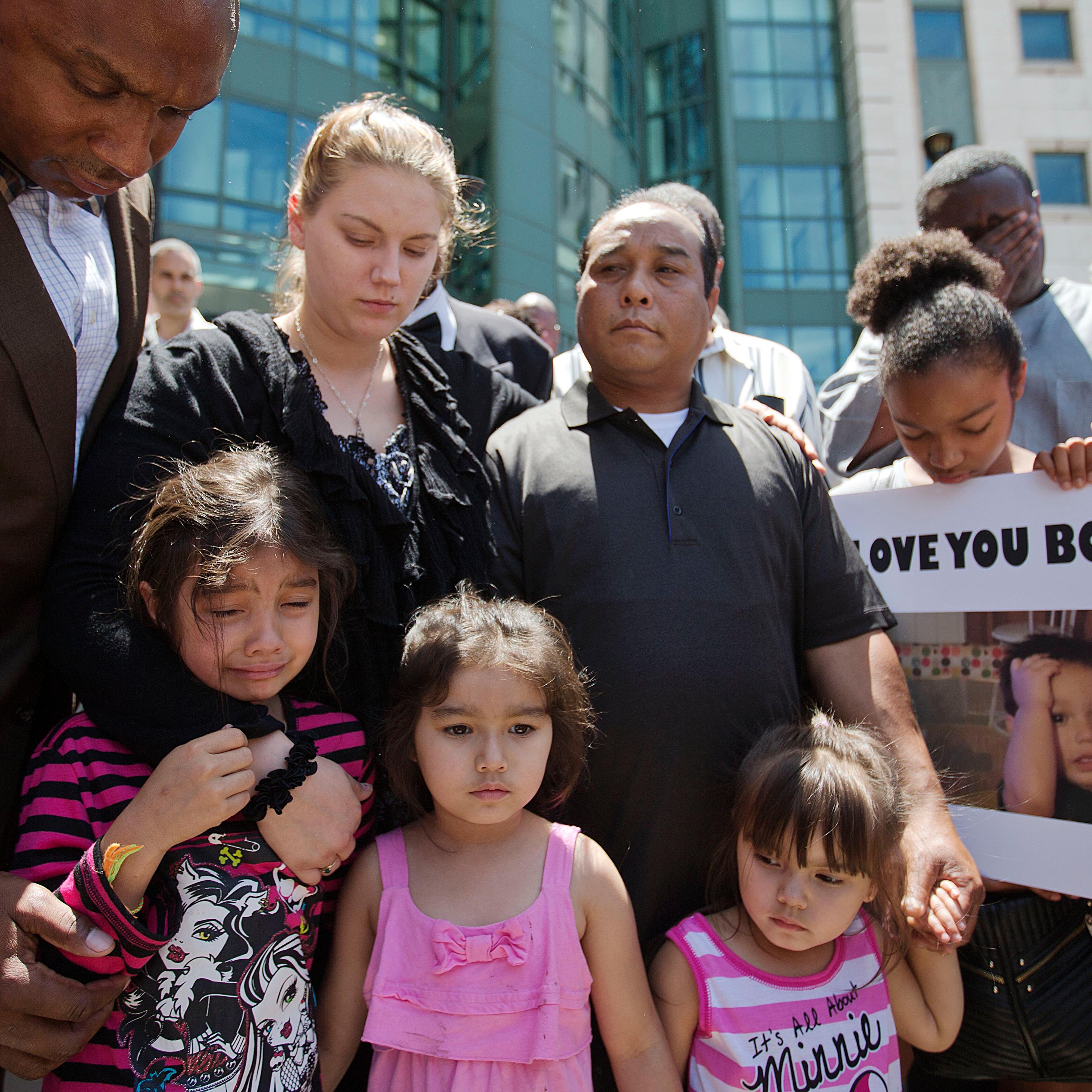 Alecia and Boun Khan Phonesavanh (center), the parents of 19-month-old Bounkham Phonesavanh who was severely burned by a flash grenade during a SWAT drug raid, attend a vigil with their daughters outside Grady Memorial Hospital where he is undergoing tre