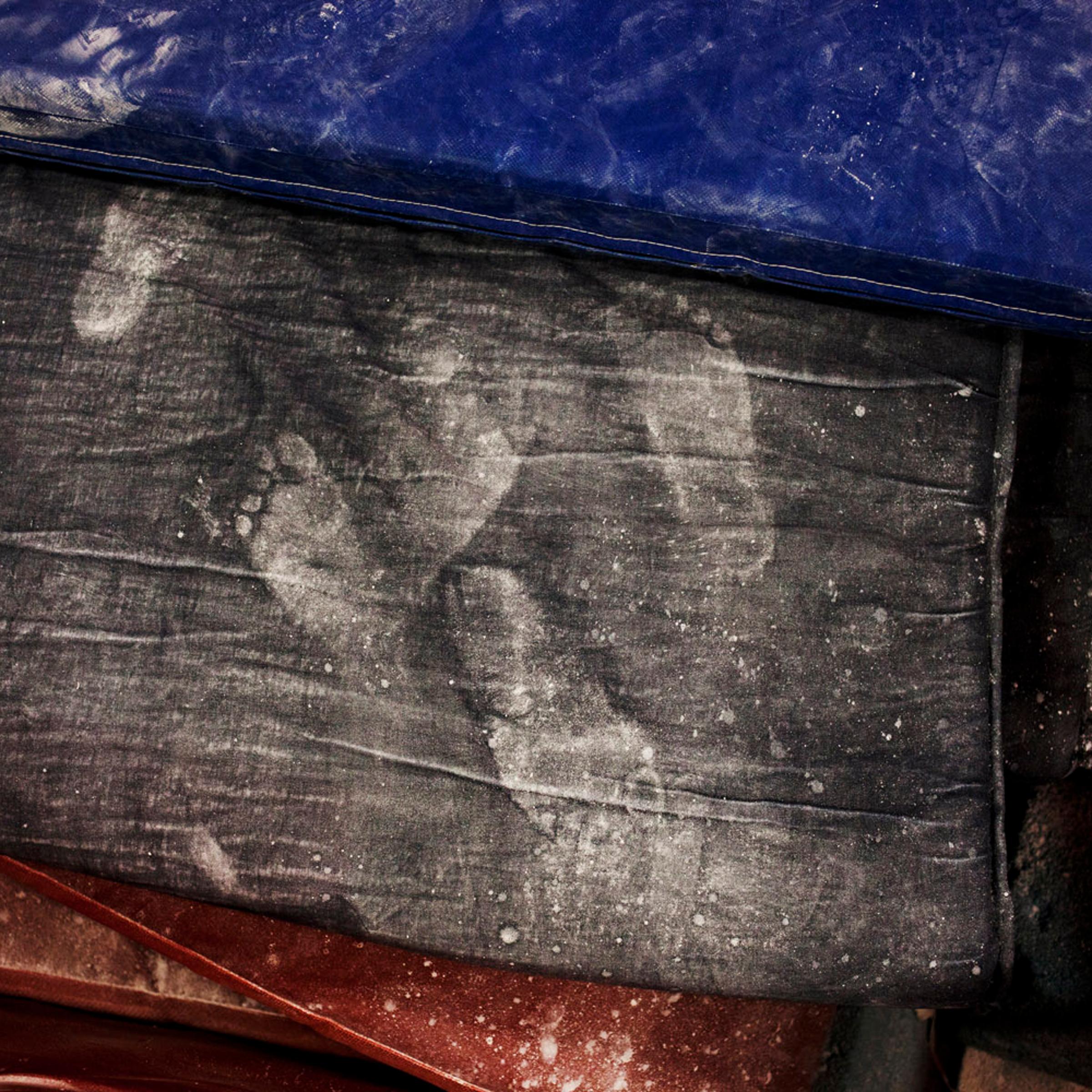 Chalky white footprints left behind on training gym mats.