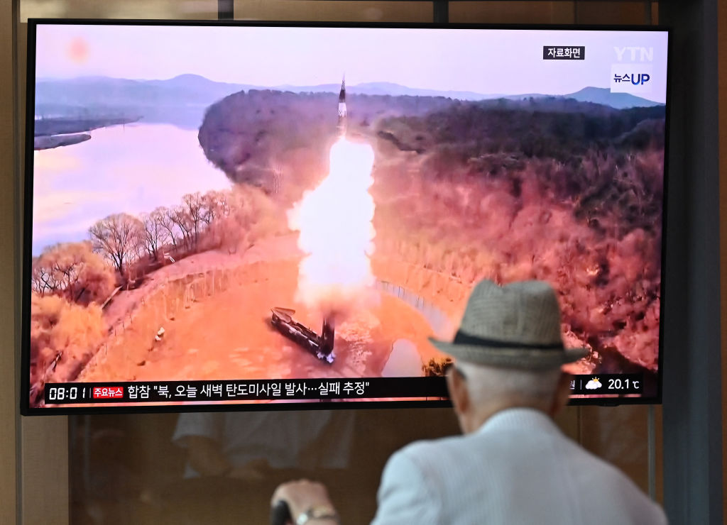 A man watches a television screen showing a news broadcast with file footage of a North Korean missile test, at a train station in Seoul on June 26, 2024.