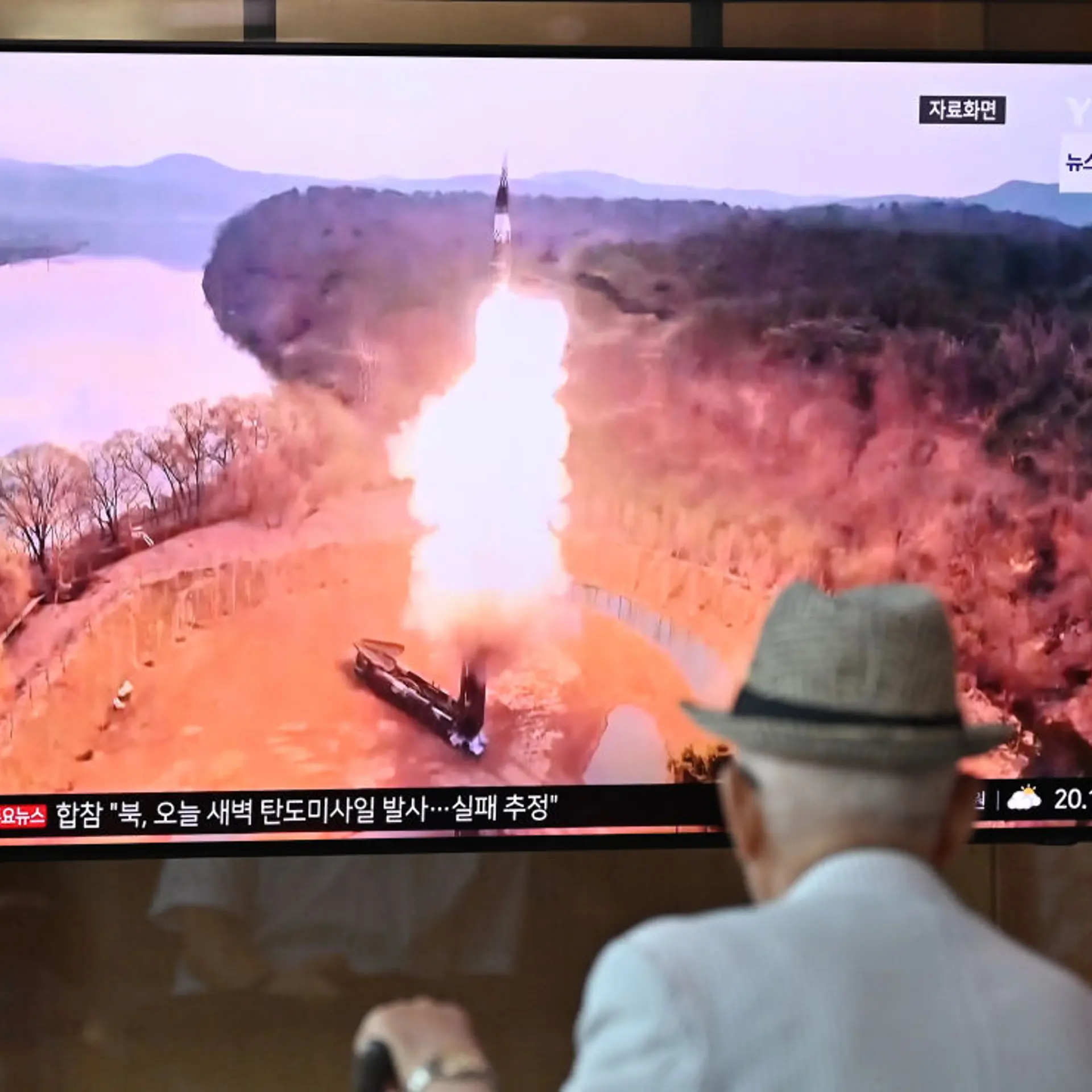 A man watches a television screen showing a news broadcast with file footage of a North Korean missile test, at a train station in Seoul on June 26, 2024.