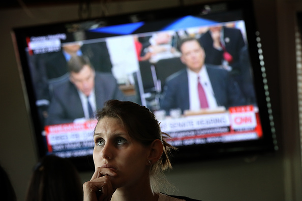 Leah Thrum joins patrons at Shaw's Tavern to watch former FBI Director James Comey testify before the Senate Intelligence Committee June 8, 2017 in Washington, DC.