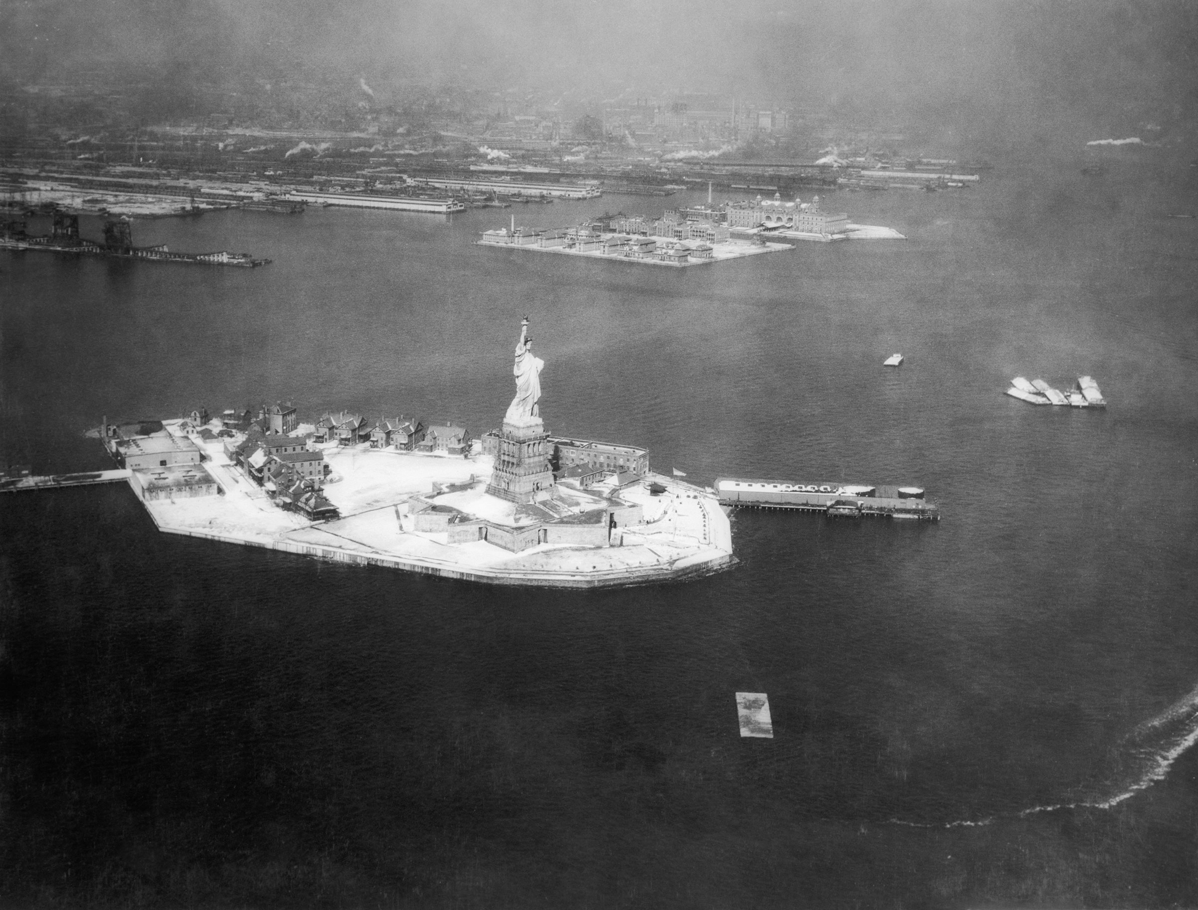 Aerial view of the Statue of Liberty, with Ellis Island in the background