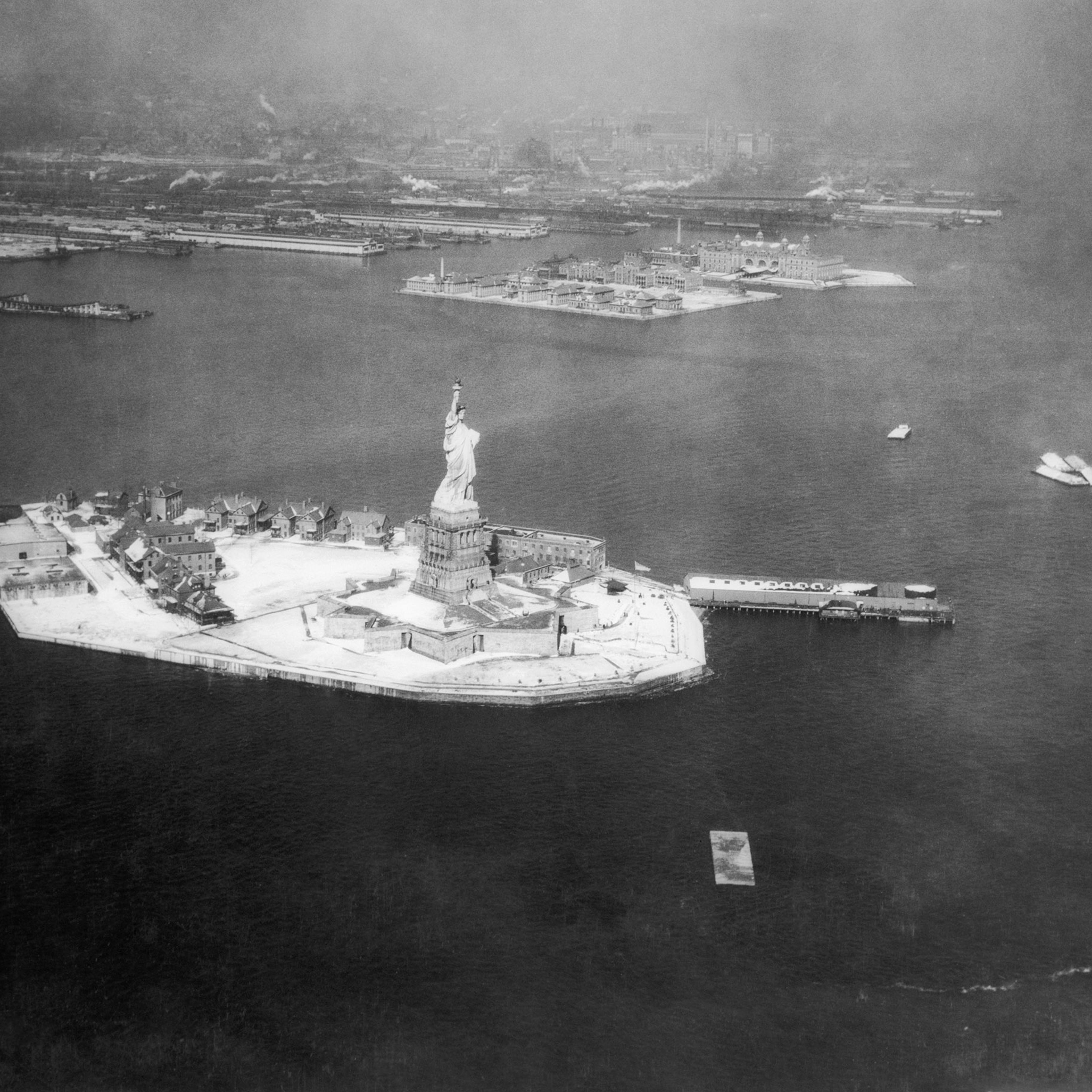 Aerial view of the Statue of Liberty, with Ellis Island in the background