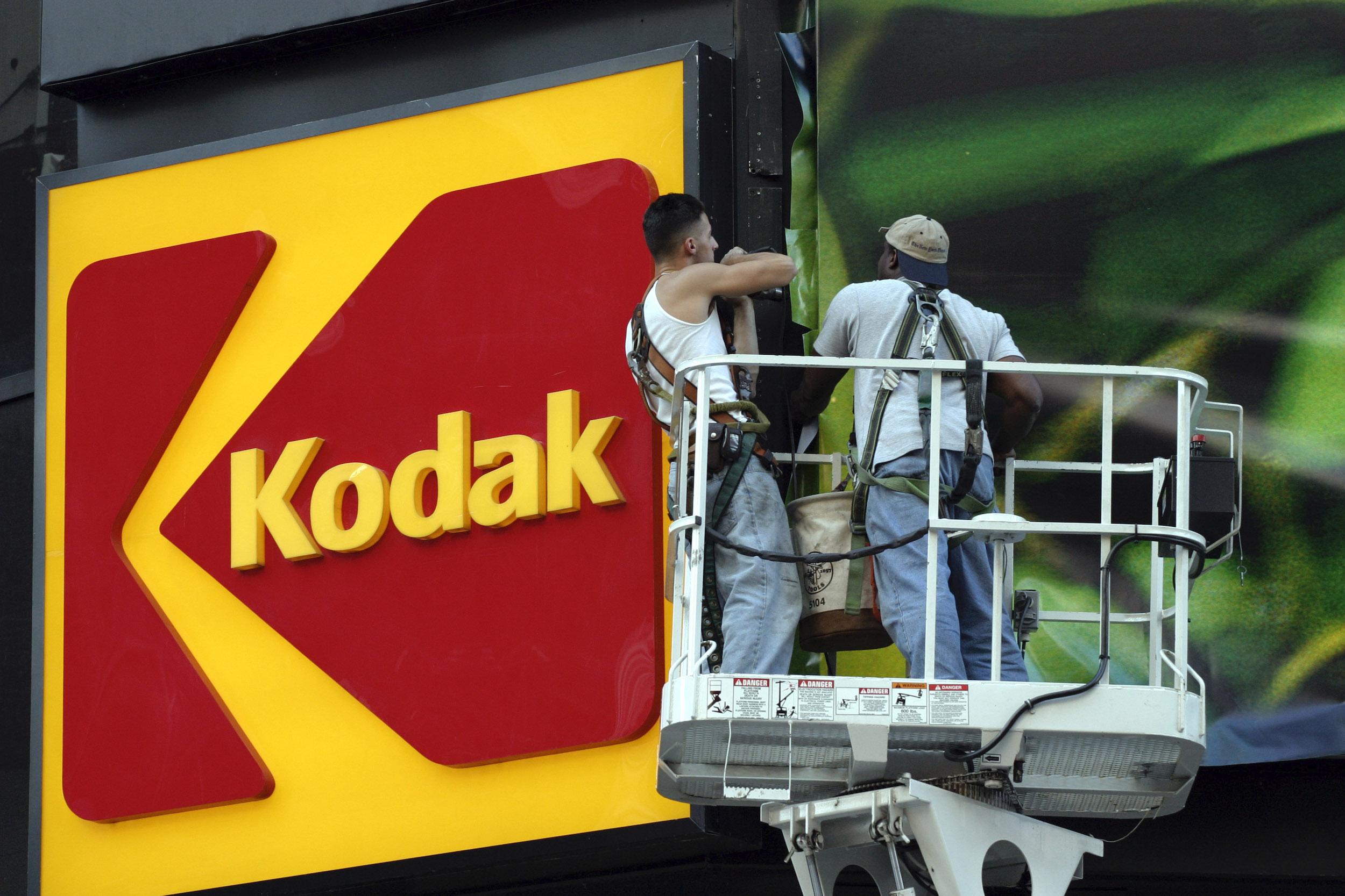Workers stand near the KODAK billboard at Times Square, New York City.