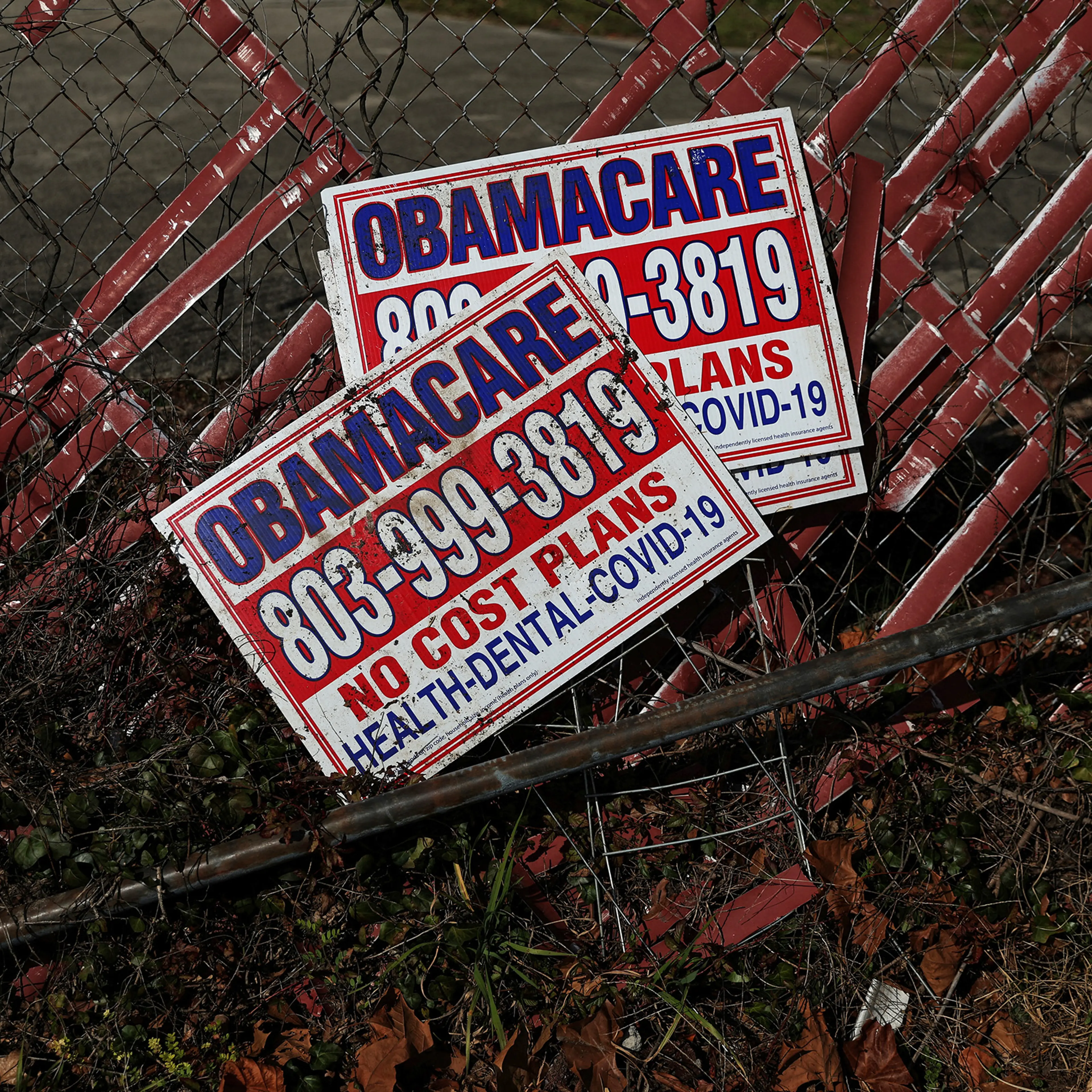 Signs for former Obamacare health insurance plans lay next to a fence in Columbia, South Carolina