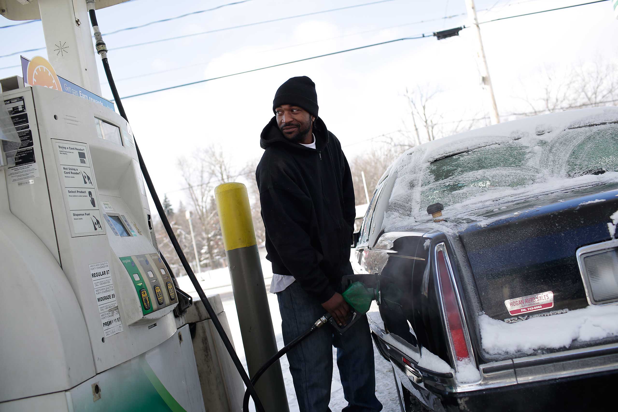 A motorist pumps fuel into his vehicle at a BP station Jan. 6, 2015 in Flint, Michigan.