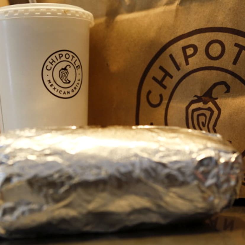 A steak burrito is arranged for a photograph with a drink and bags of chips at a Chipotle Mexican Grill Inc. restaurant in Hollywood, California, U.S., on Tuesday, July 16, 2013.