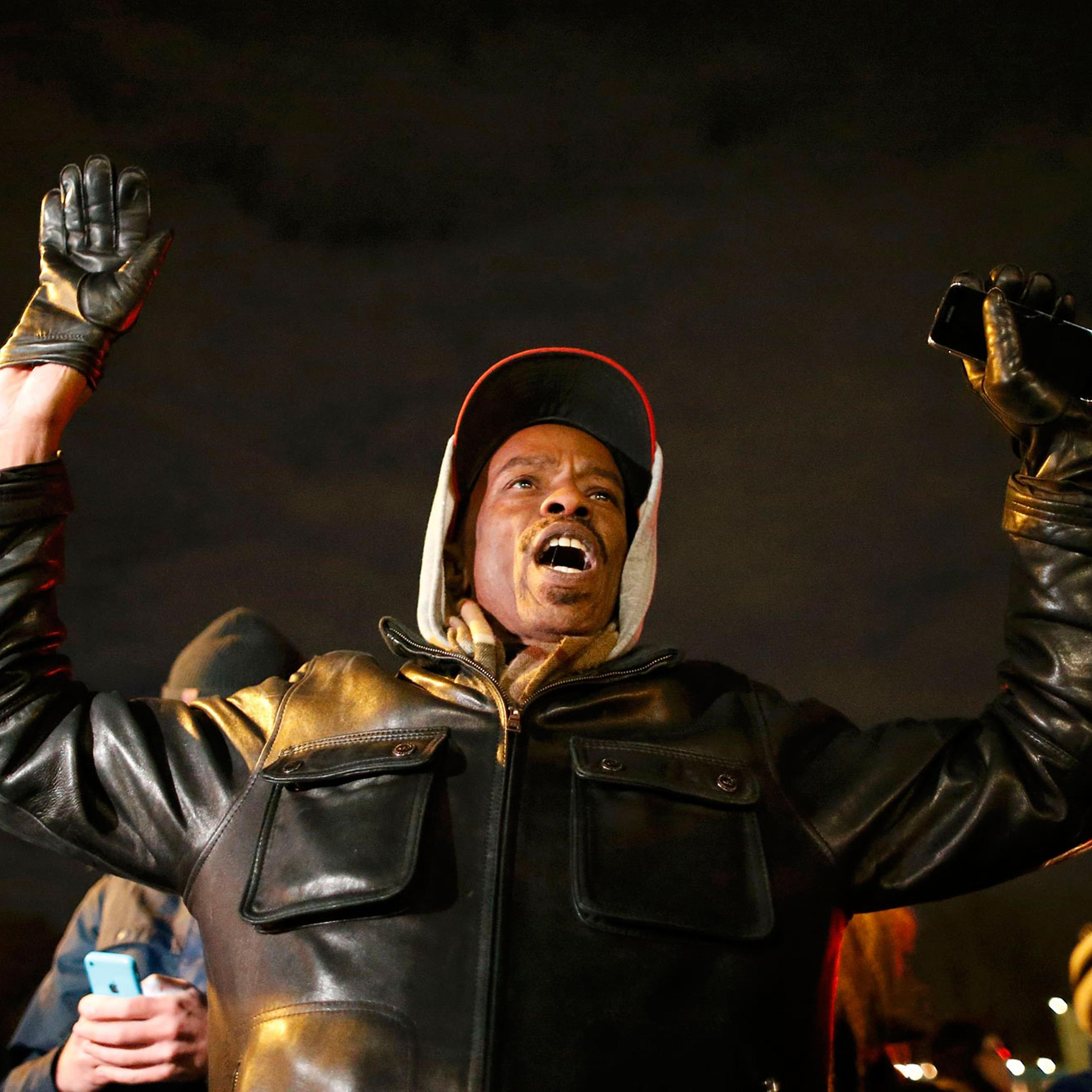 A protester holds his hands in the air outside the Ferguson Police Department in Ferguson