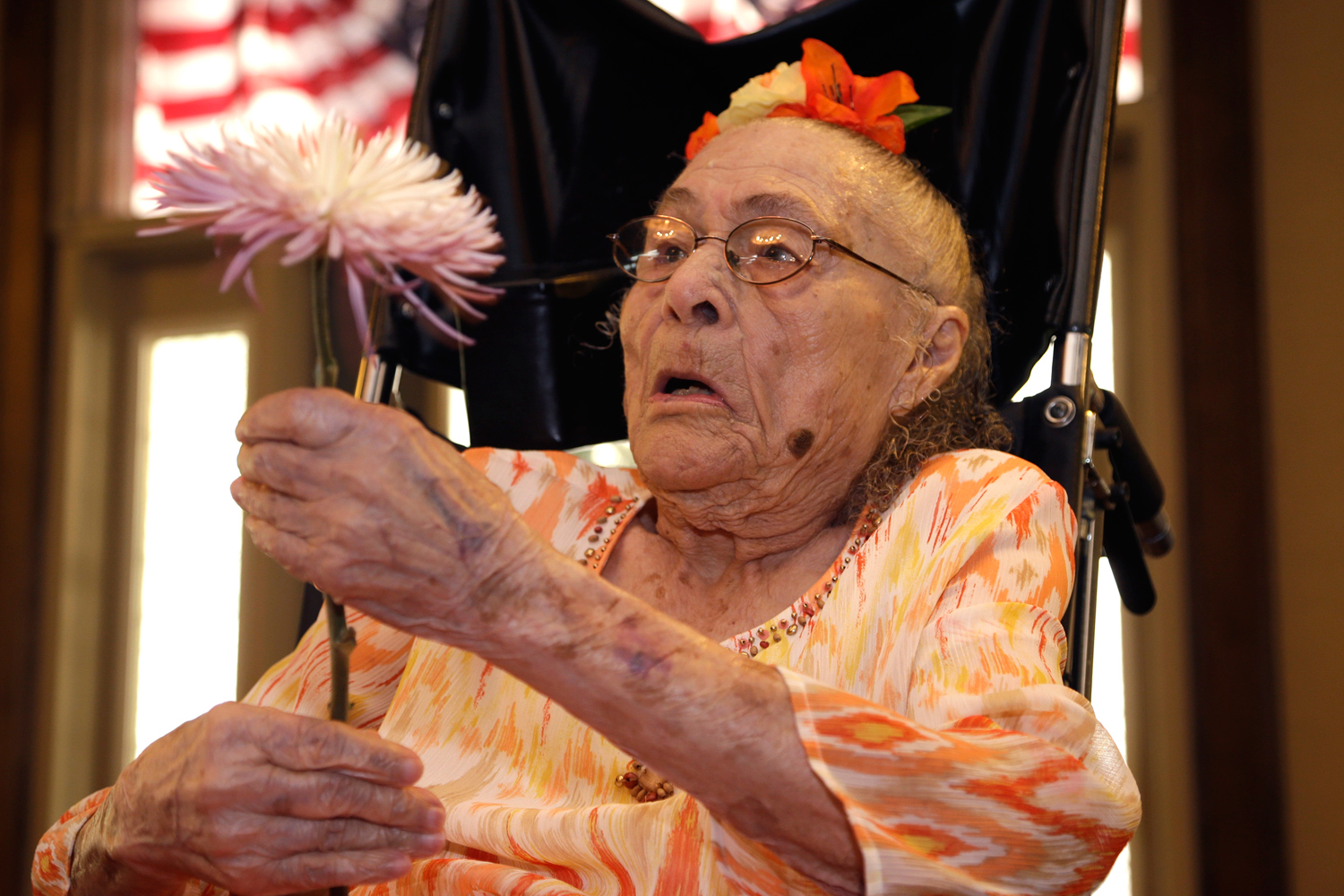 Gertrude Weaver holds a flower given to her a day before her 116th birthday at Silver Oaks Health and Rehabilitation in Camden, Ark on July 3, 2014.