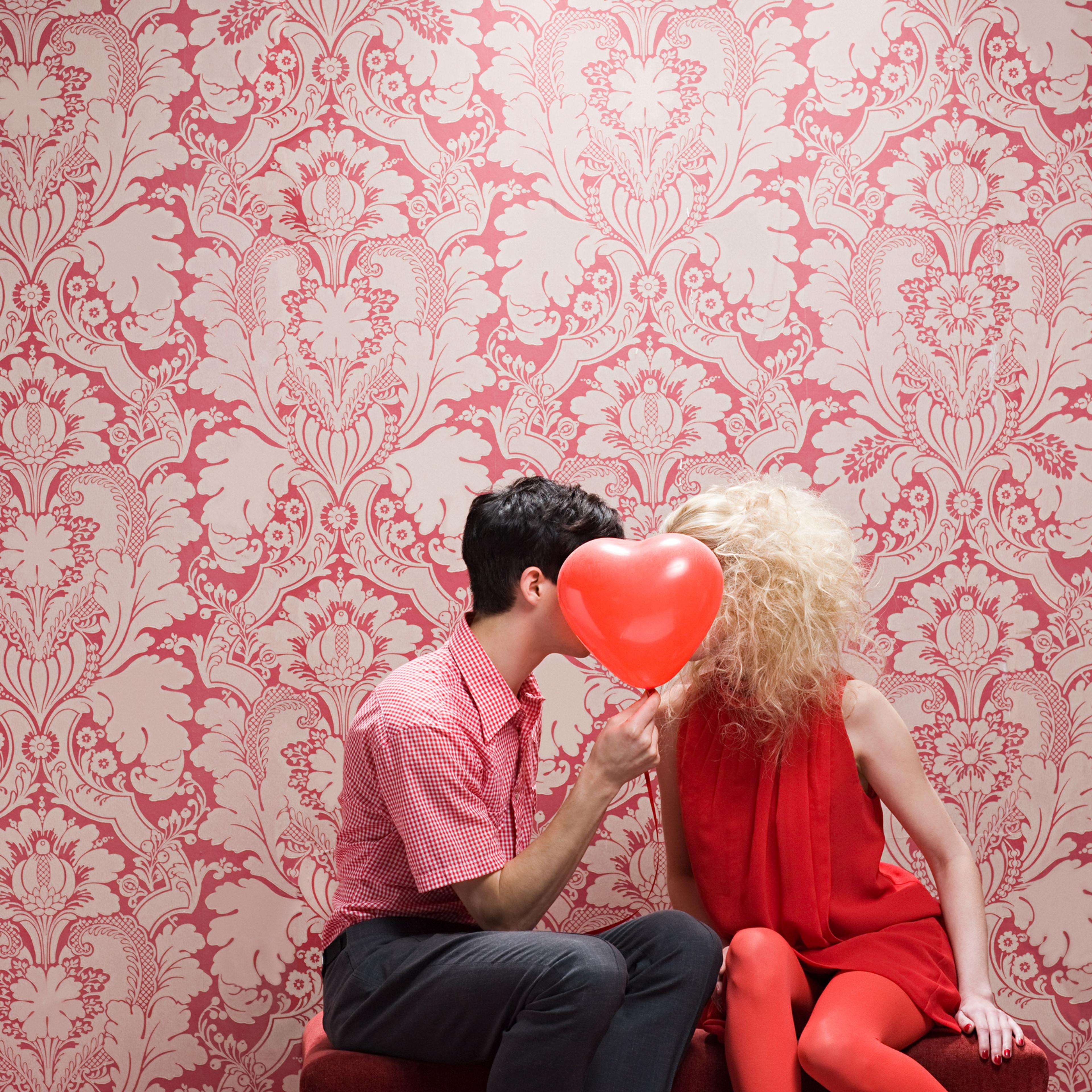 Couple behind heart shaped balloon